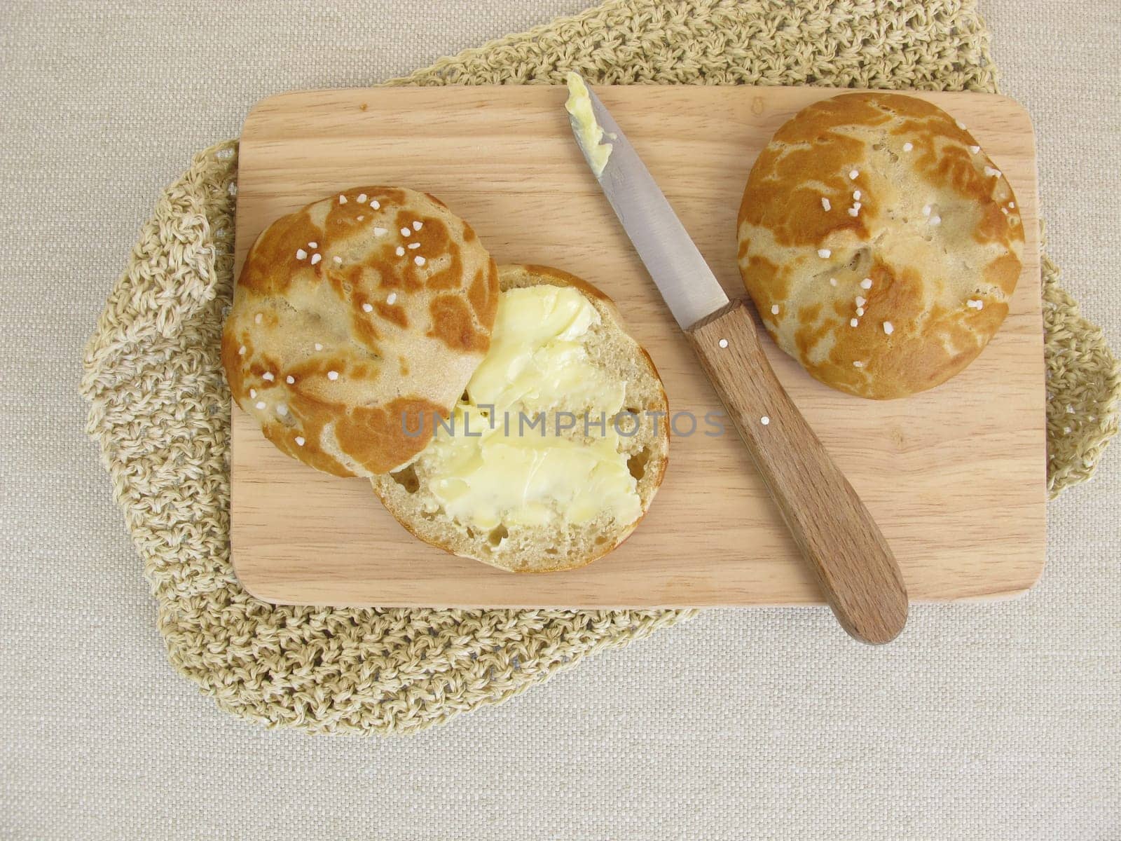 Sliced homemade pretzel rolls with butter