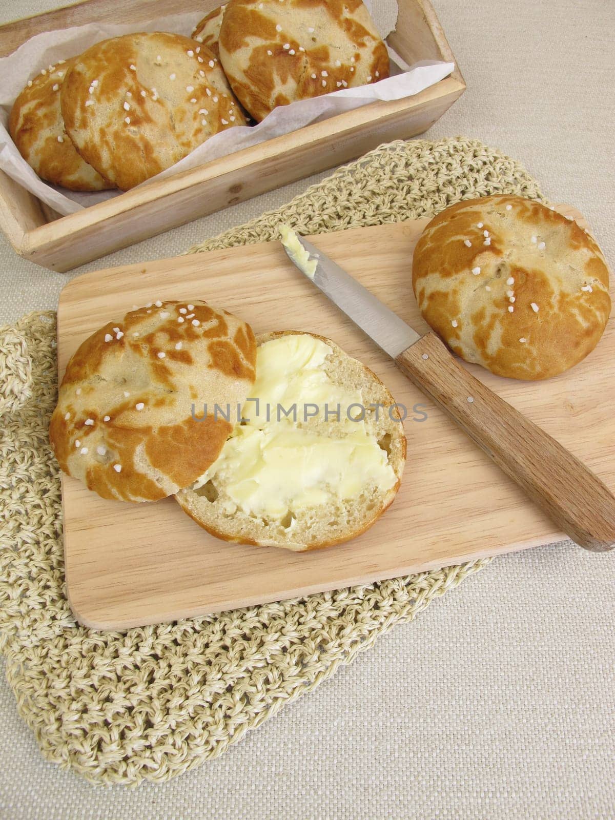 Sliced homemade pretzel rolls with butter