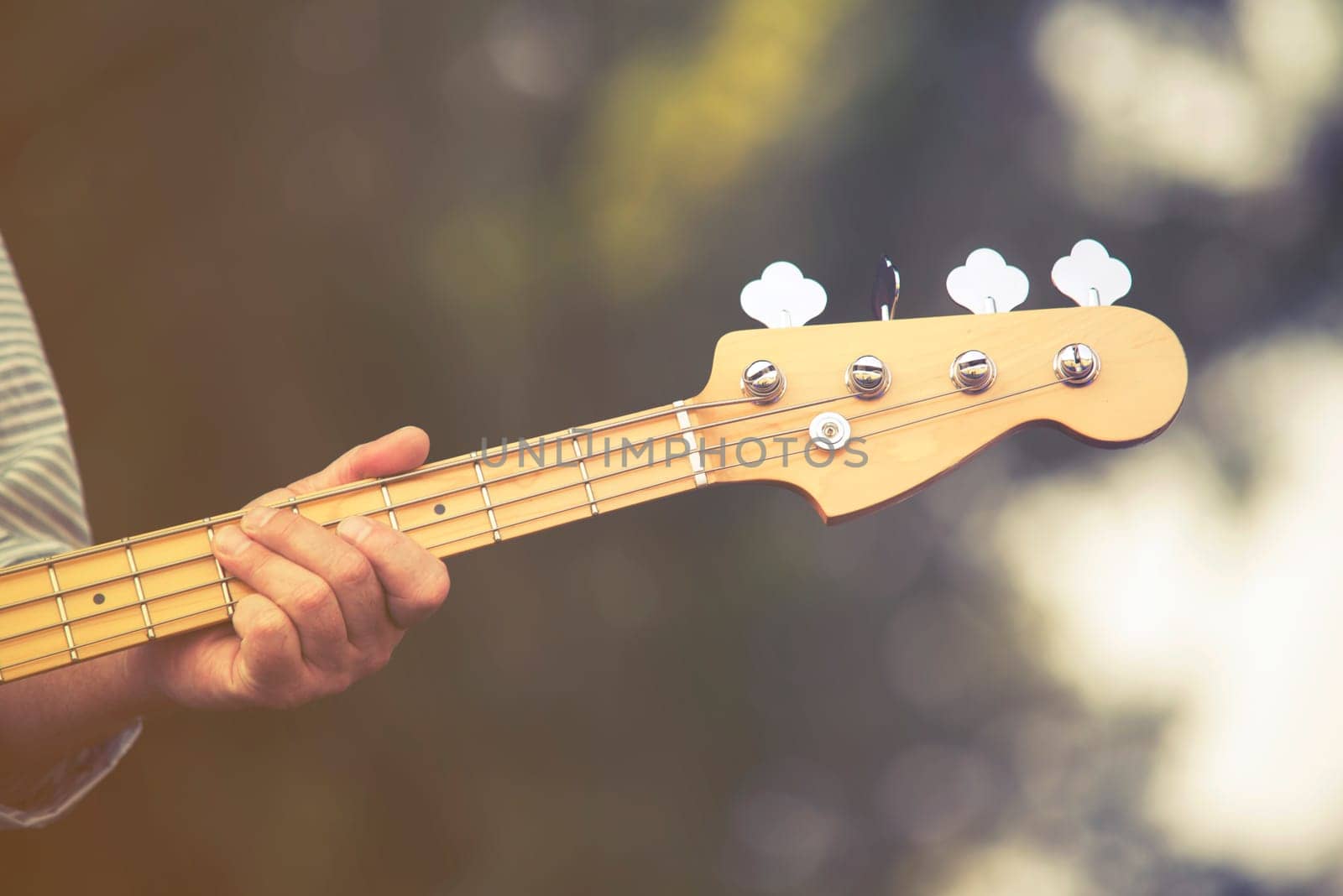 close up on man play on bass guitar