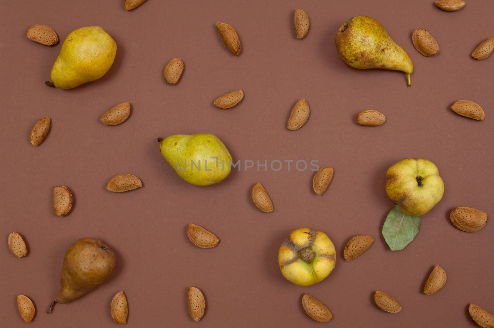 Autumn pear and nut pattern on brown background top view horizontal
