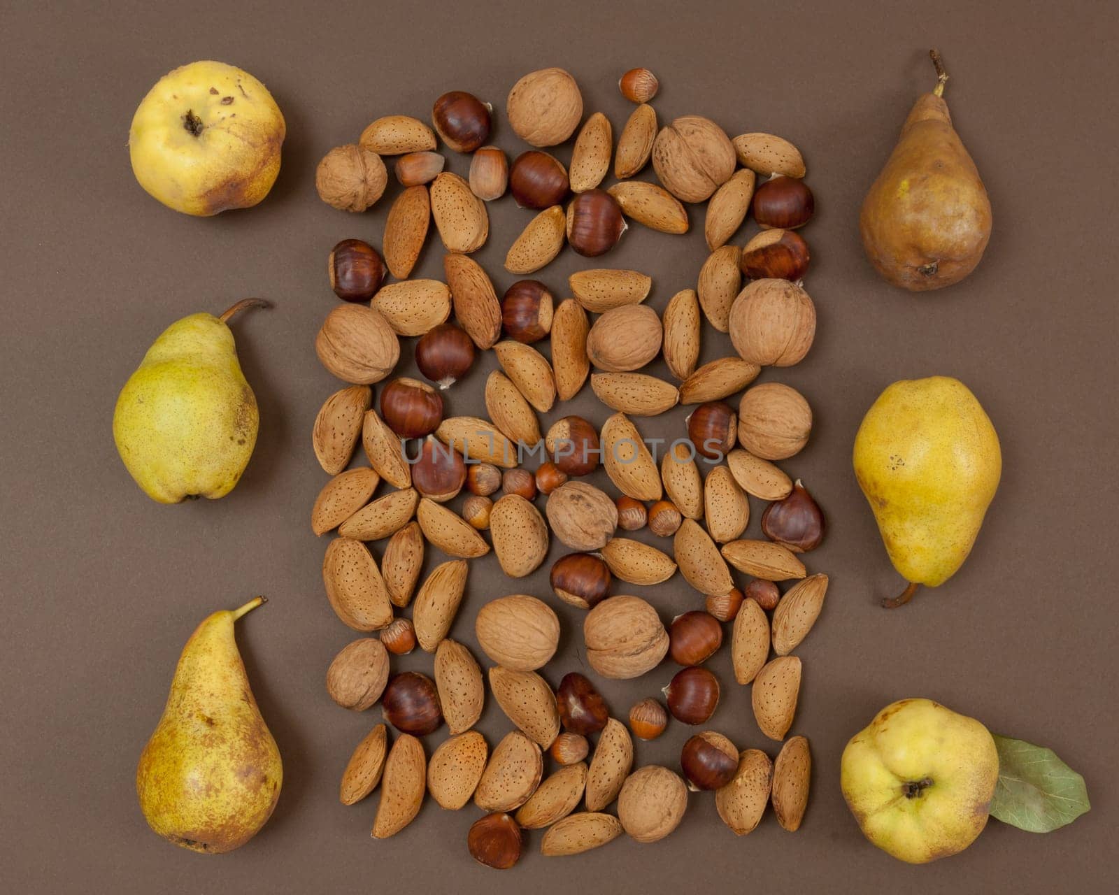 Autumn pear and nut pattern on brown background top view square