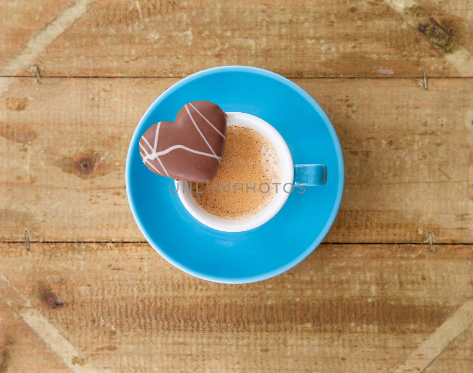 Small cup of coffee with heart-shaped chocolate biscuits
