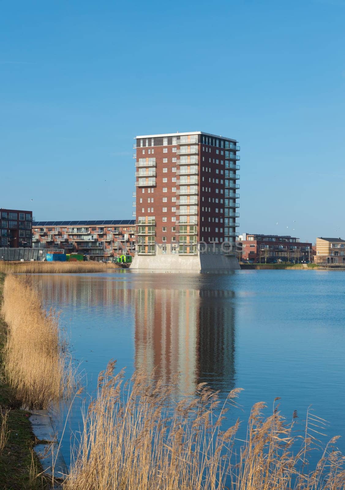 modern apartment building reflected in a lake