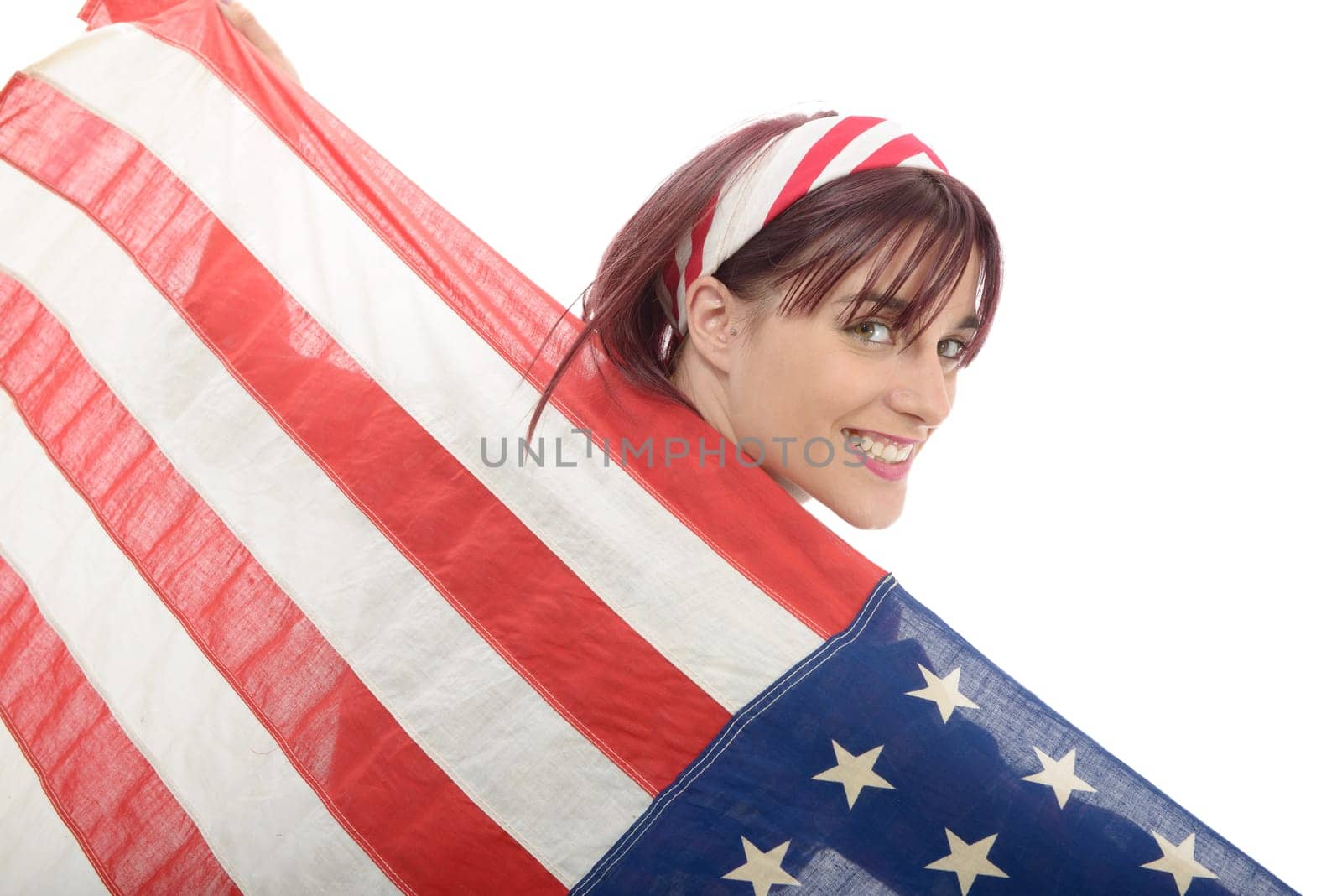 a pretty young woman isolated holding an American Flag, back view