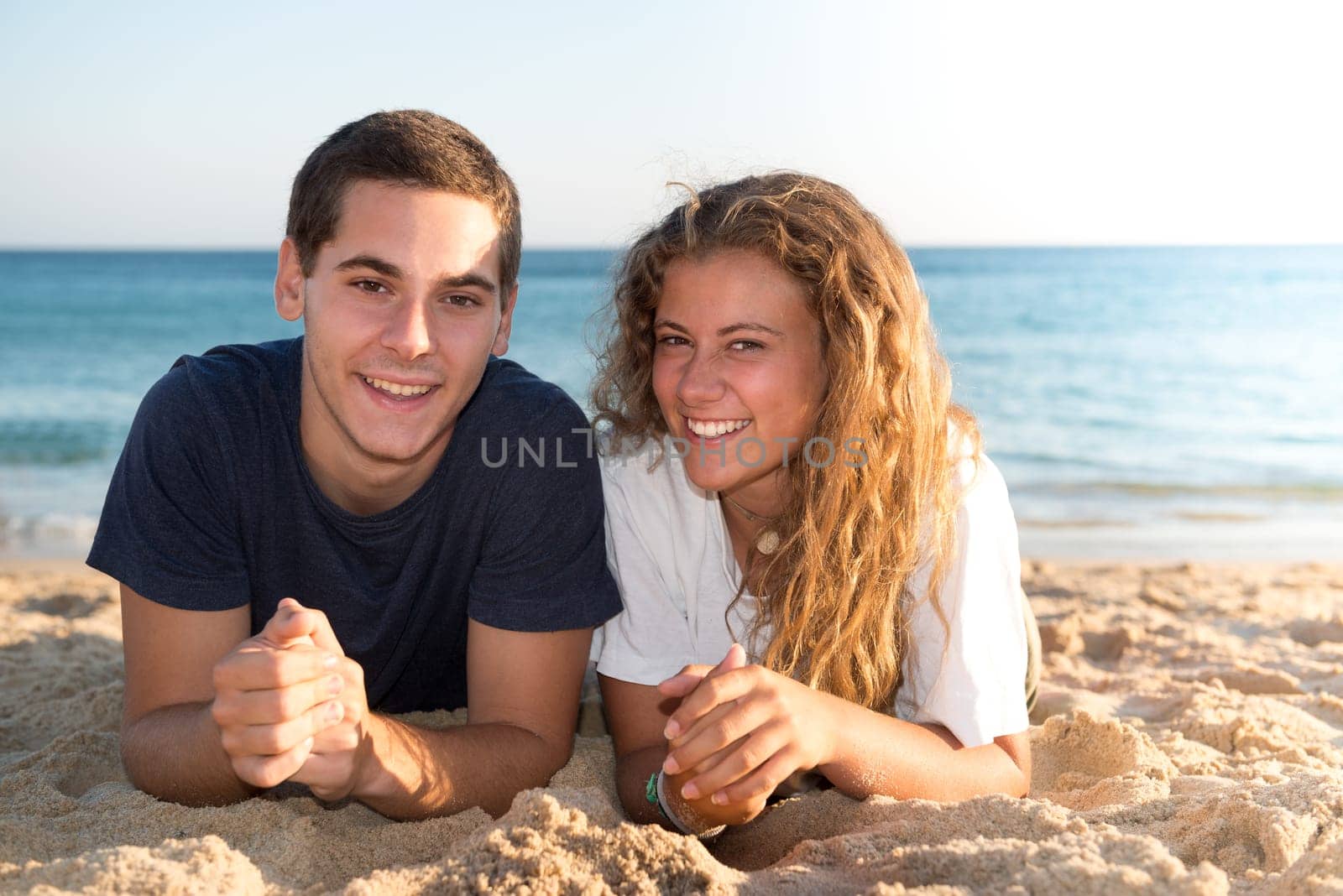 Happy teenage couple posing in the beach