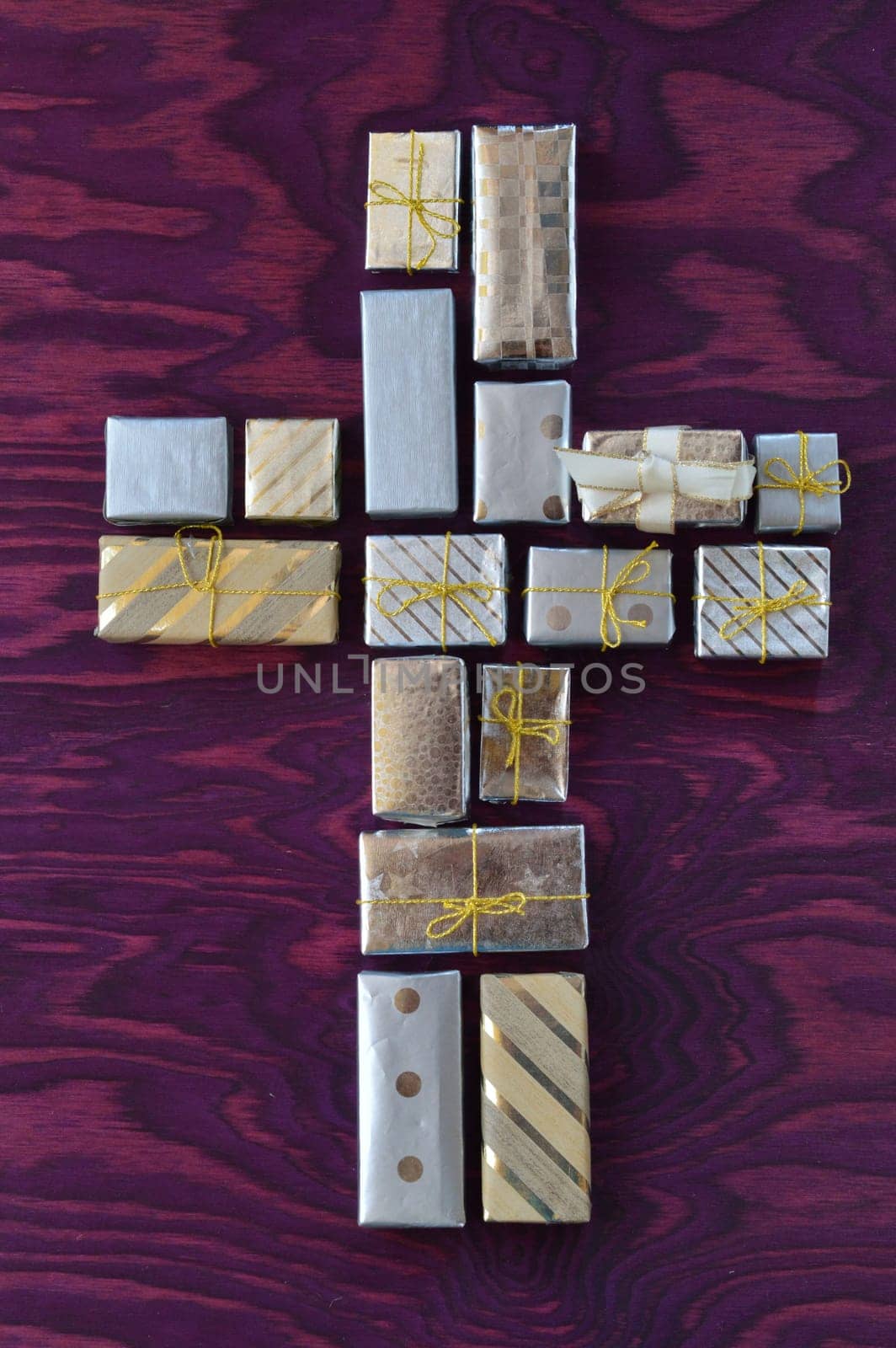 many small gifts on purple wood form a cross