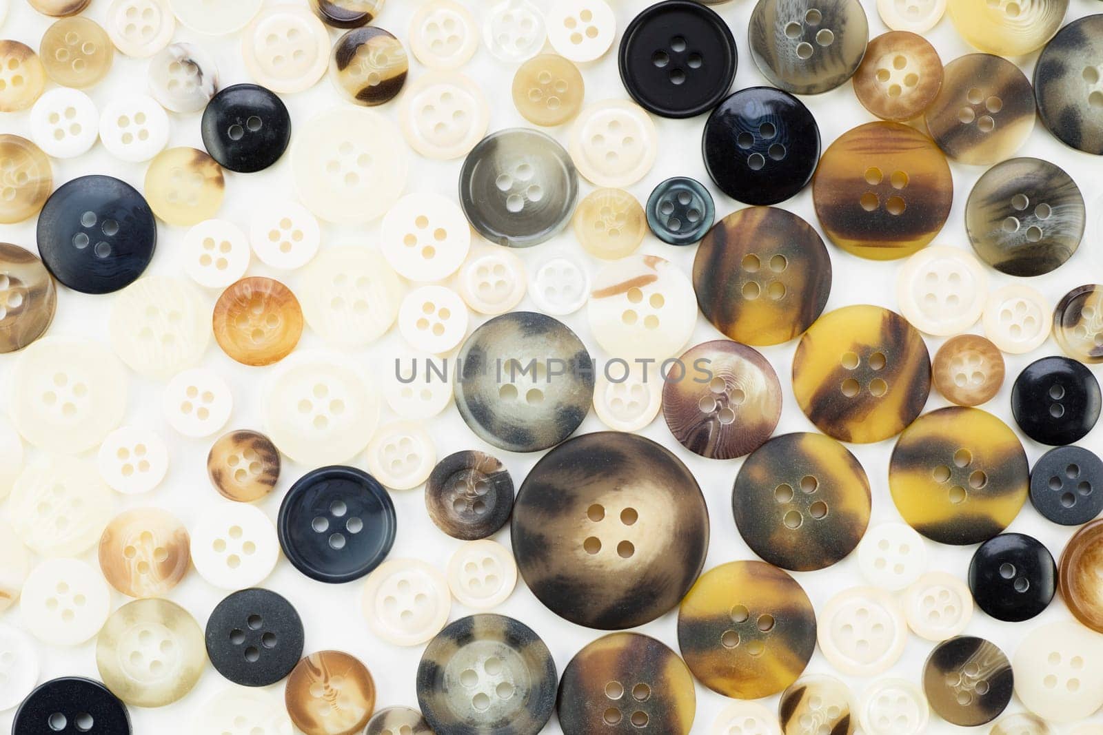 Texture of buttons in browns, white and black tones.