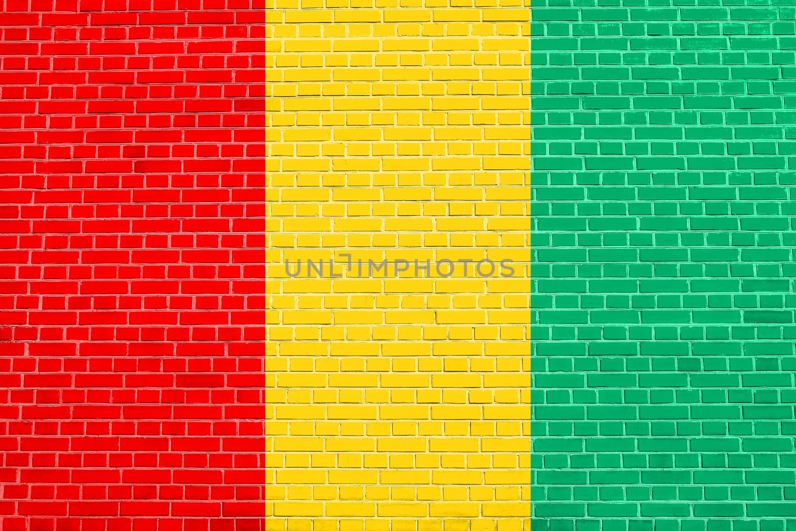 Guinean national official flag. African patriotic symbol, banner, element, background. Flag of Guinea on brick wall texture background
