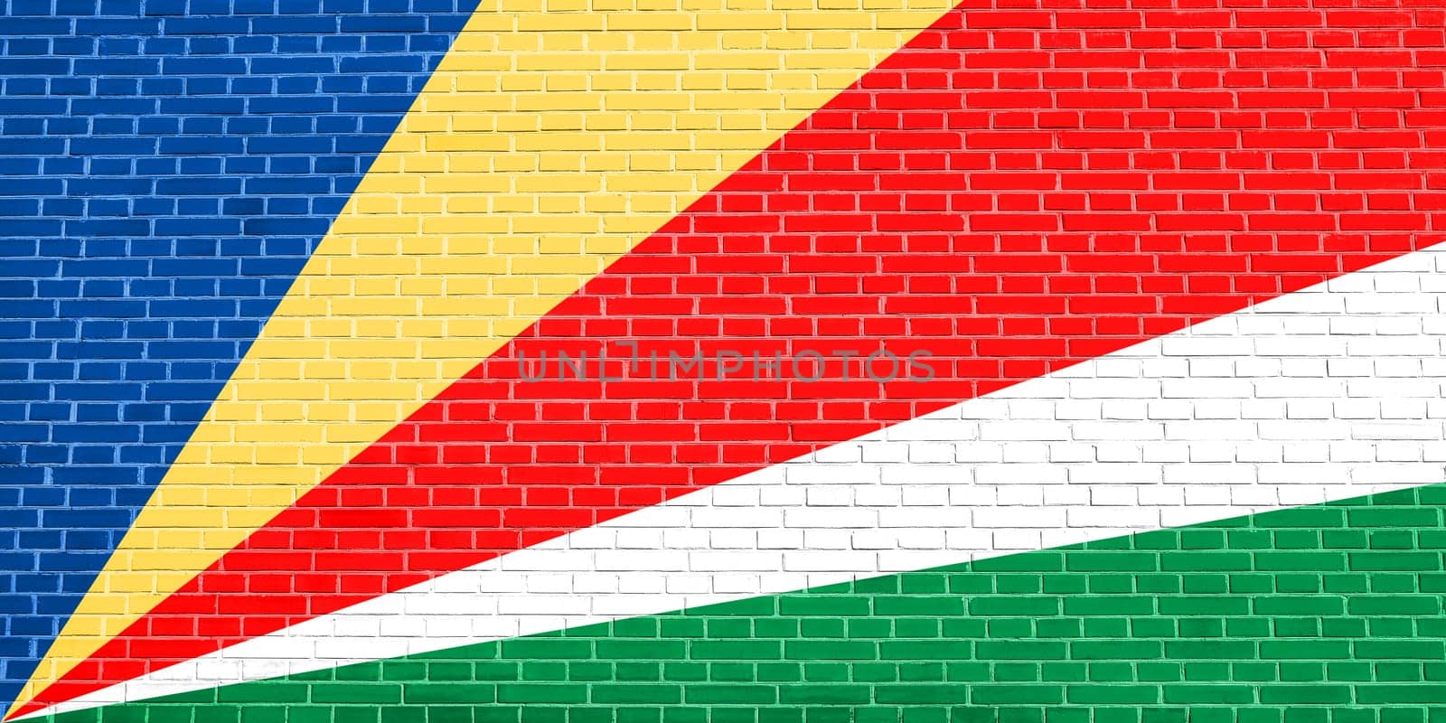Seychellois national official flag. African patriotic symbol, banner, element, background. Flag of Seychelles on brick wall texture background