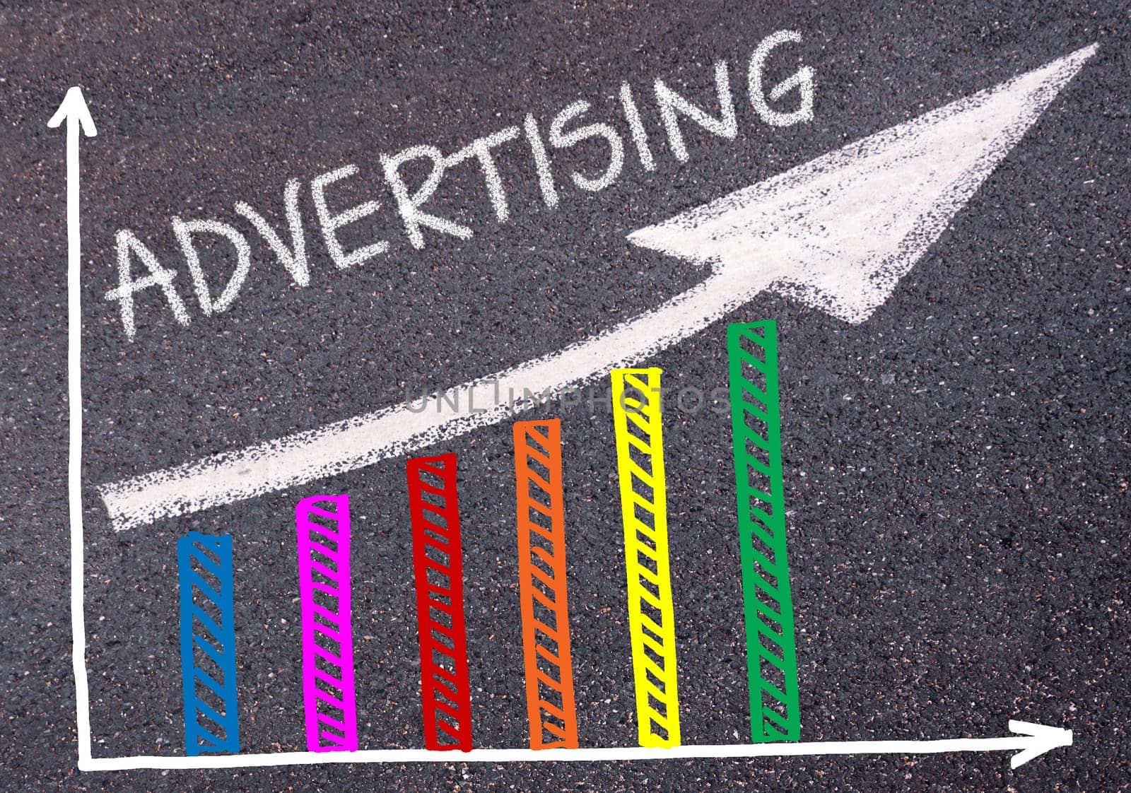 ADVERTISING written with chalk on tarmac over colorful graph and rising arrow, business marketing and creativity concept