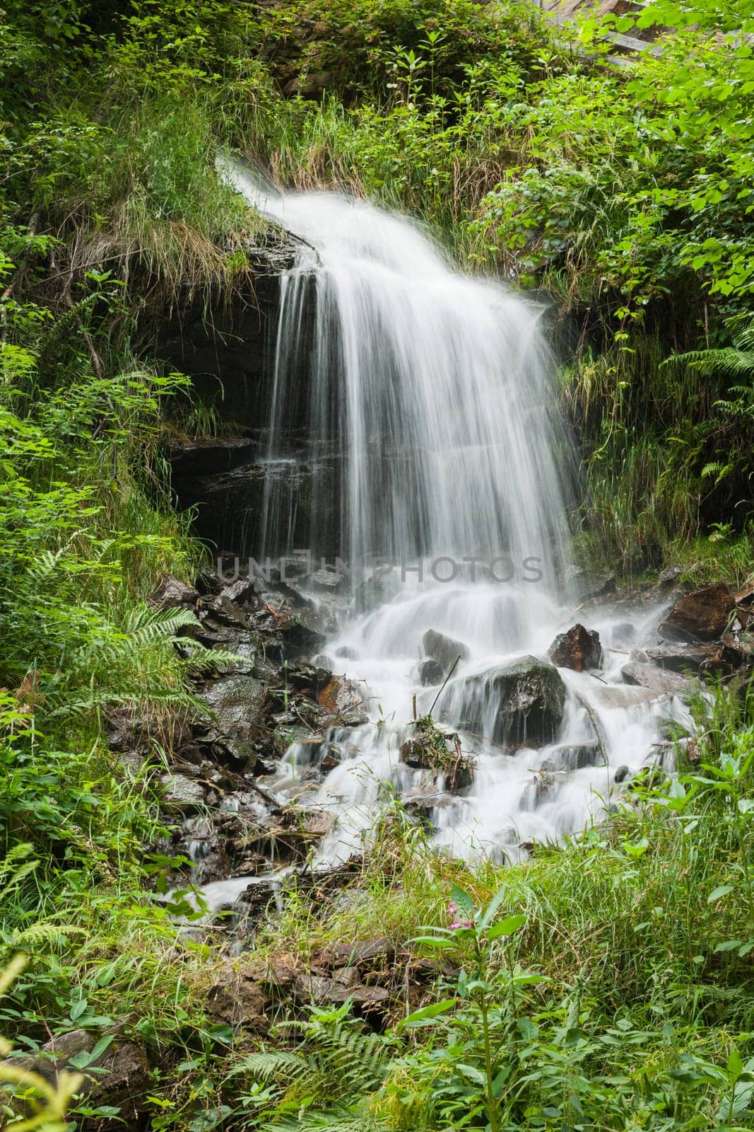 Long-term exposure of a small waterfall in the South Tyrolean Alps above the city of Merano in summer.