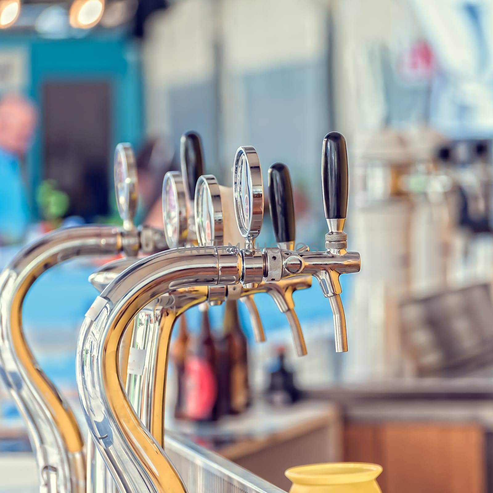 Draught beer taps and other beverages in a bar.