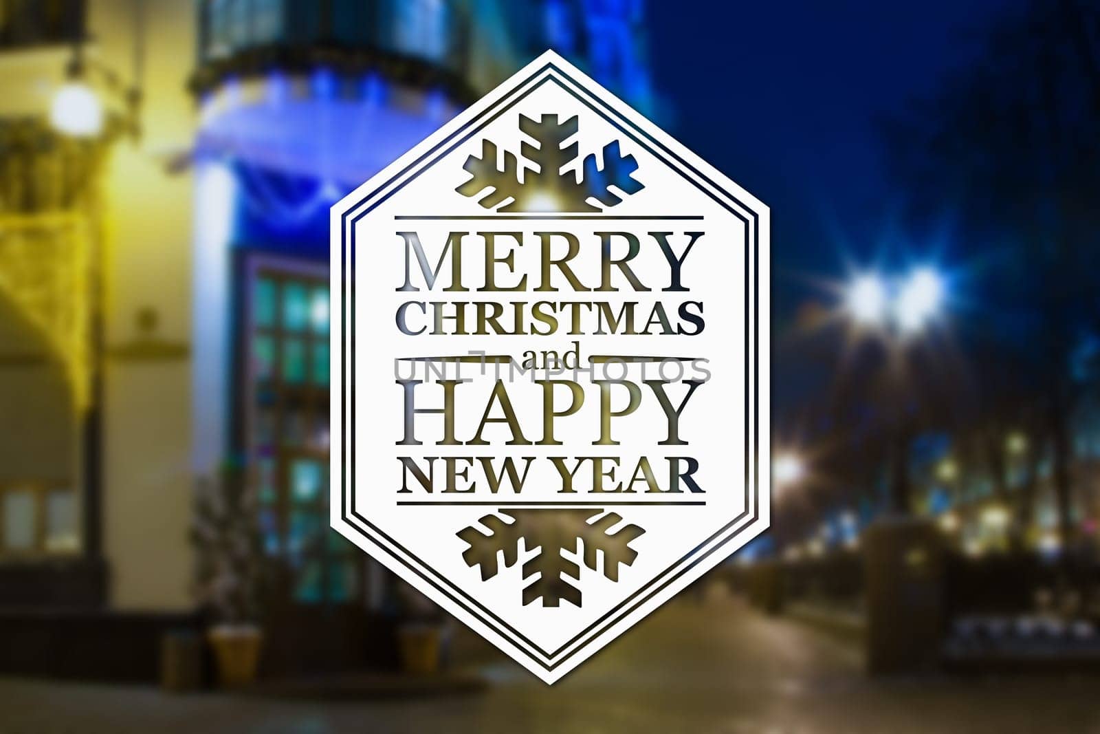 Merry Christmas and New Year greeting card on blurred night city streets illuminated buildings background