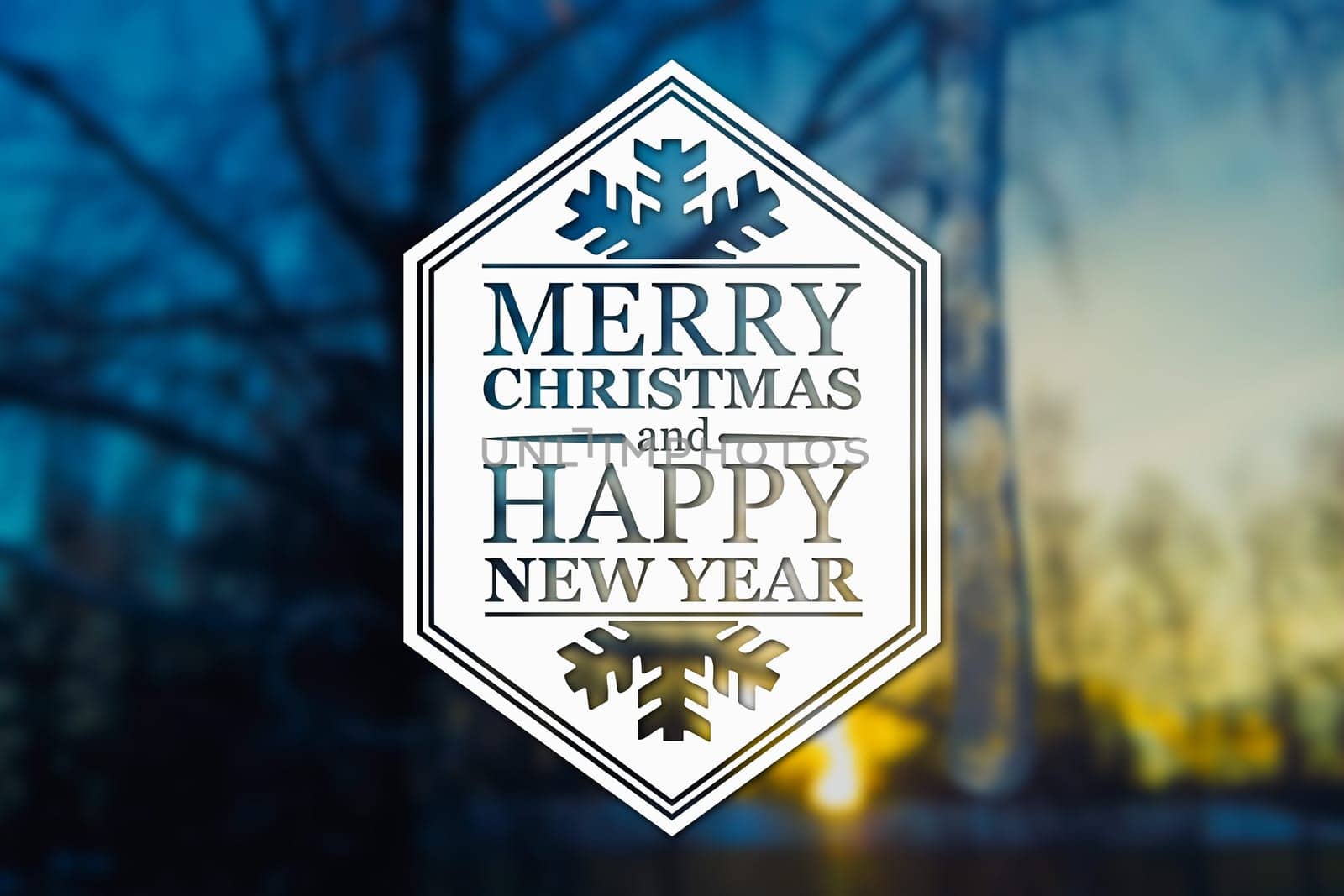 Merry Christmas and New Year greeting card on blurred tree and icicle at sunset blue colored background