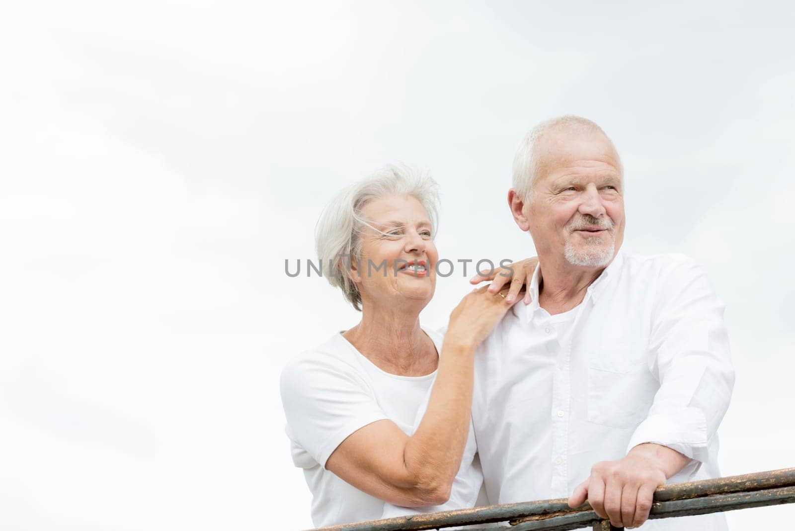 Active and happy senior couple in front of a bright sky