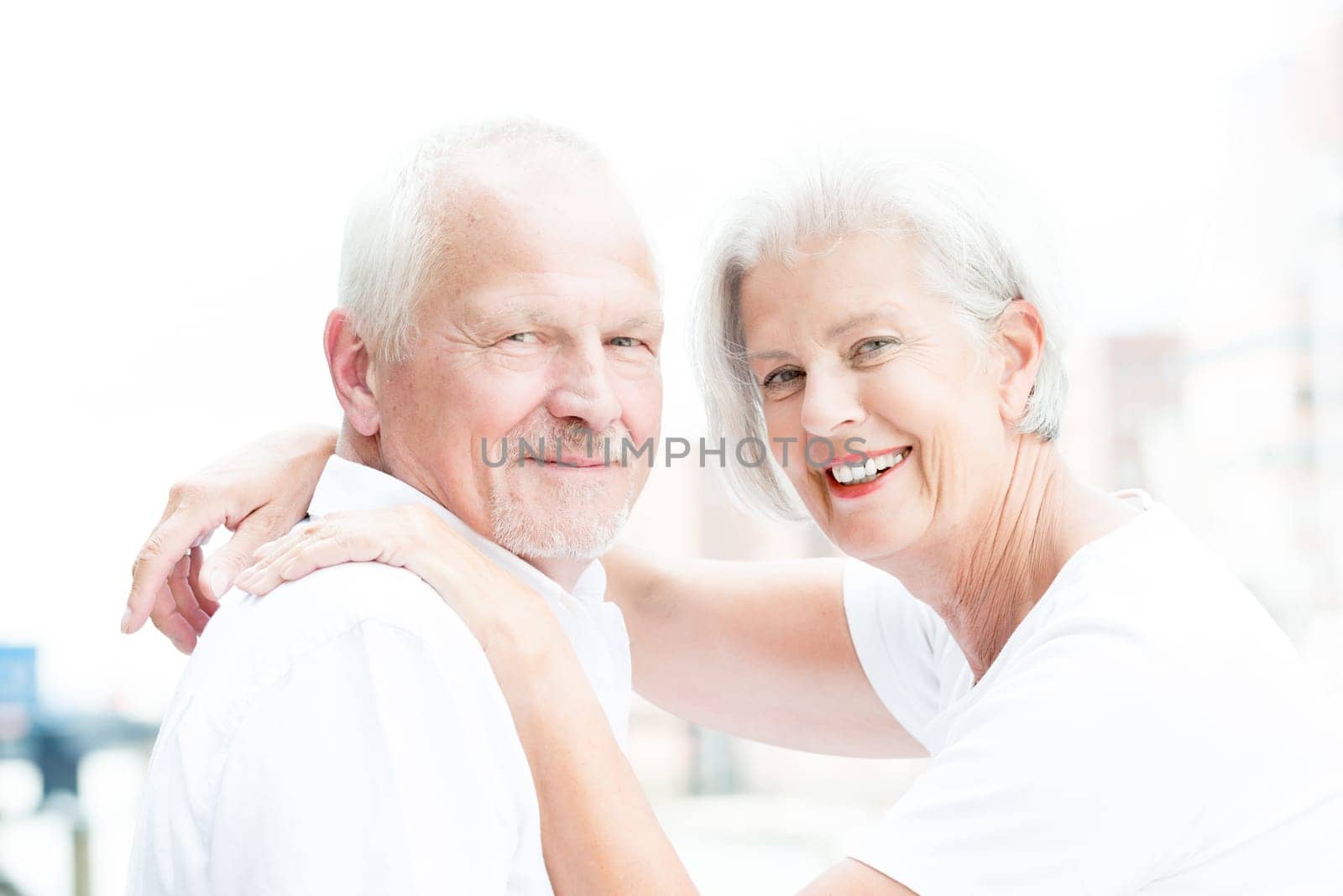 Active and happy senior couple in front of a bright sky