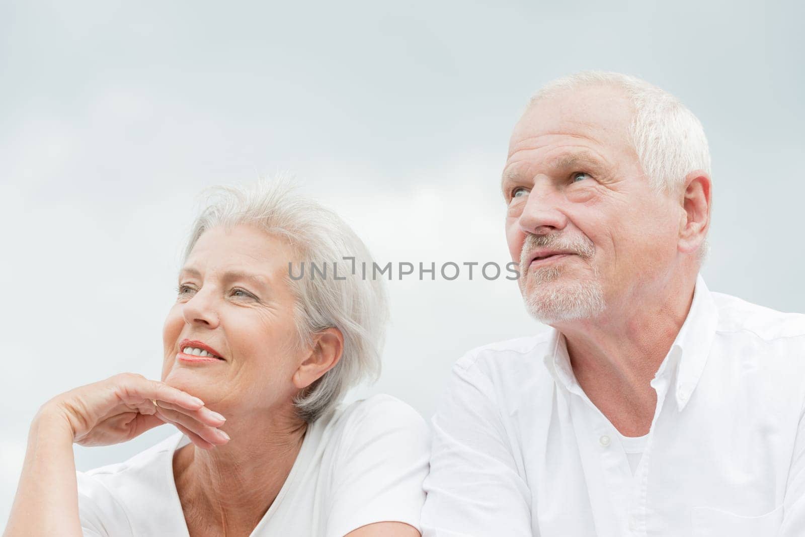 Active and happy senior couple in front of a bright sky