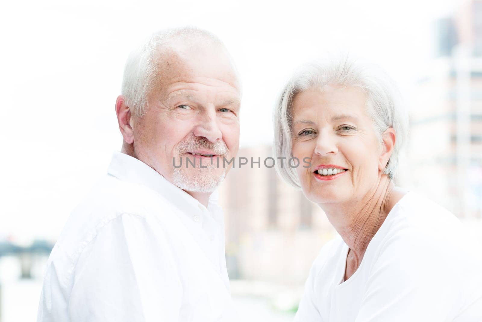 Active and happy senior couple in front of a bright sky