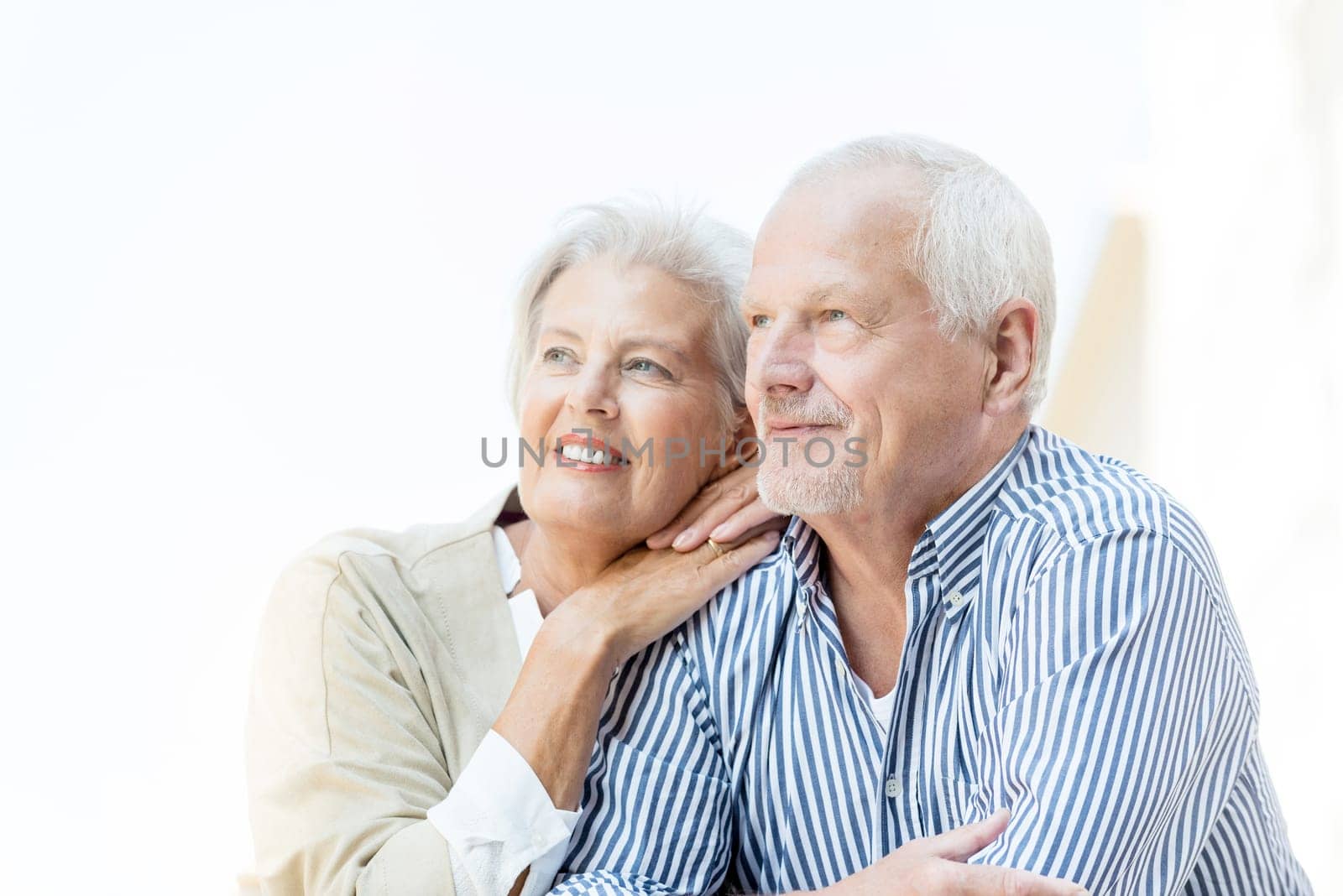 Active and happy senior couple in front of a white sky