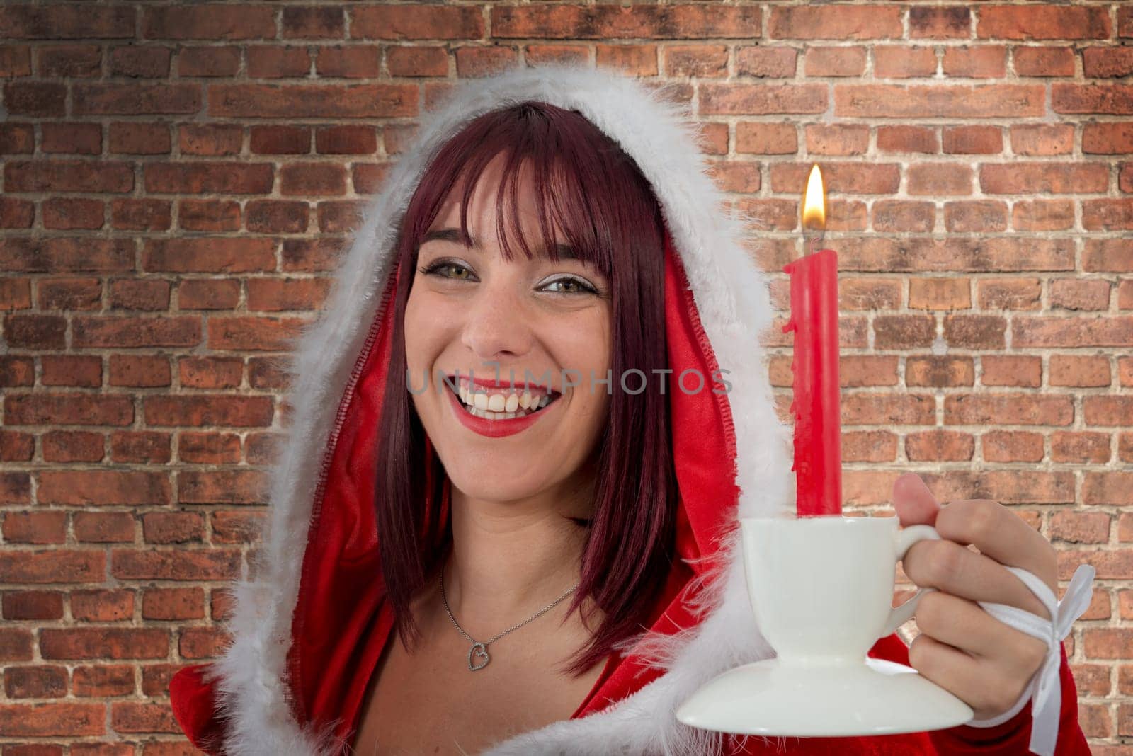a sexy attractive young female Santa Claus with candle