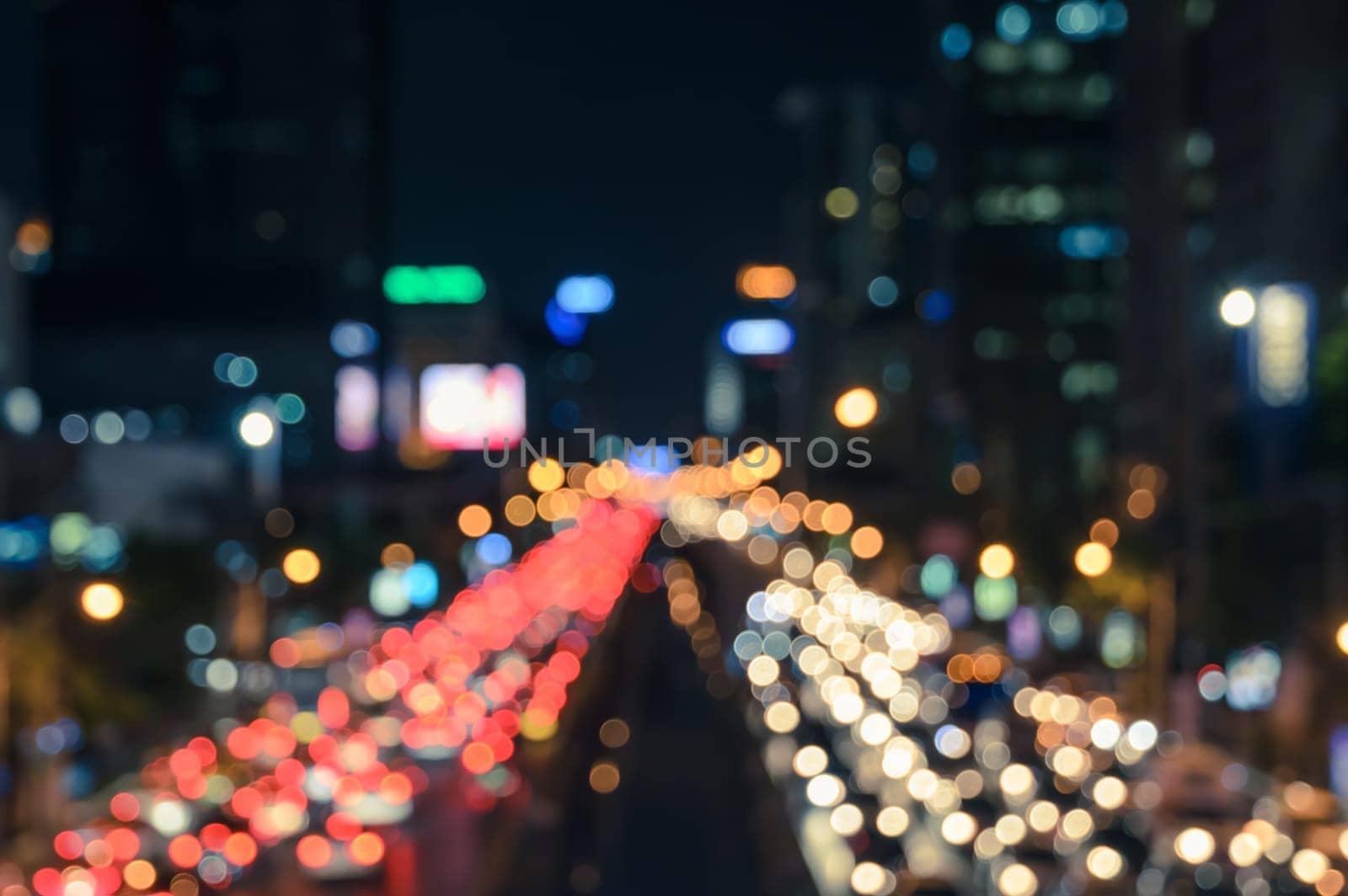 Blurred bokeh image of traffic jam in business area downtown. Defocused image of city night light