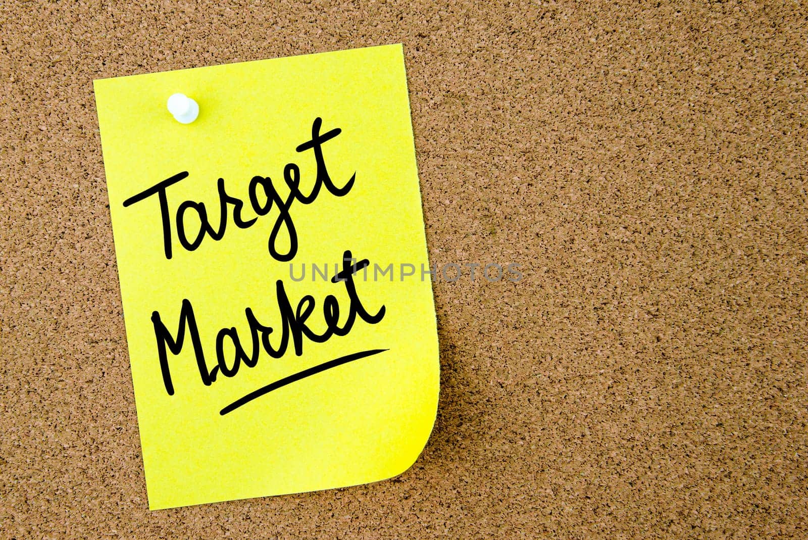 Target Market text written on yellow paper note pinned on cork board with white thumbtack. Business concept image with copy space available