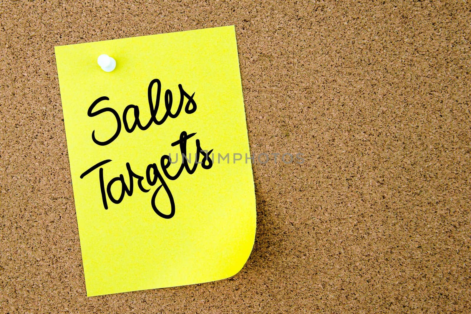 Sales Targets text written on yellow paper note pinned on cork board with white thumbtack. Business concept image with copy space available