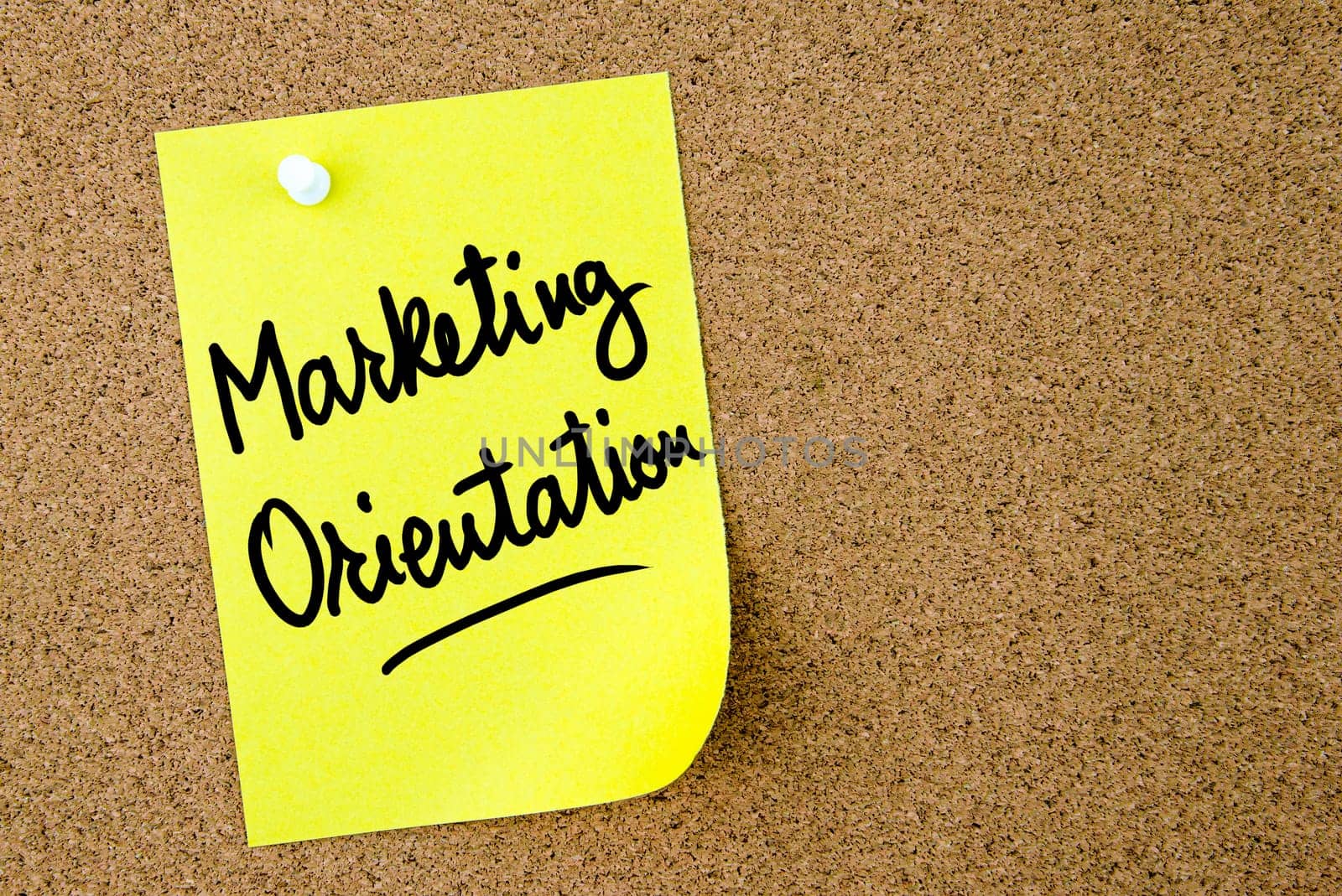 Marketing Orientation text written on yellow paper note pinned on cork board with white thumbtack. Business concept image with copy space available