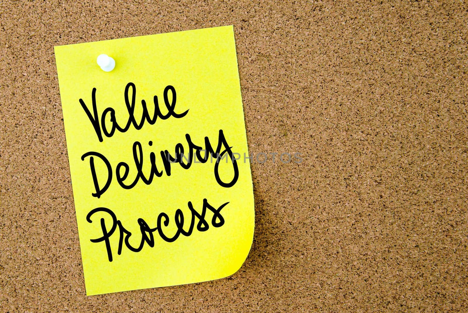 Value Delivery Process text written on yellow paper note pinned on cork board with white thumbtack. Business concept image with copy space available