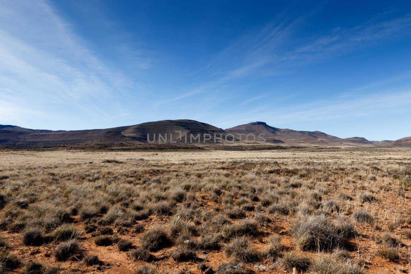 Full view of the mountains with green grass field in Graaff-Reinet.