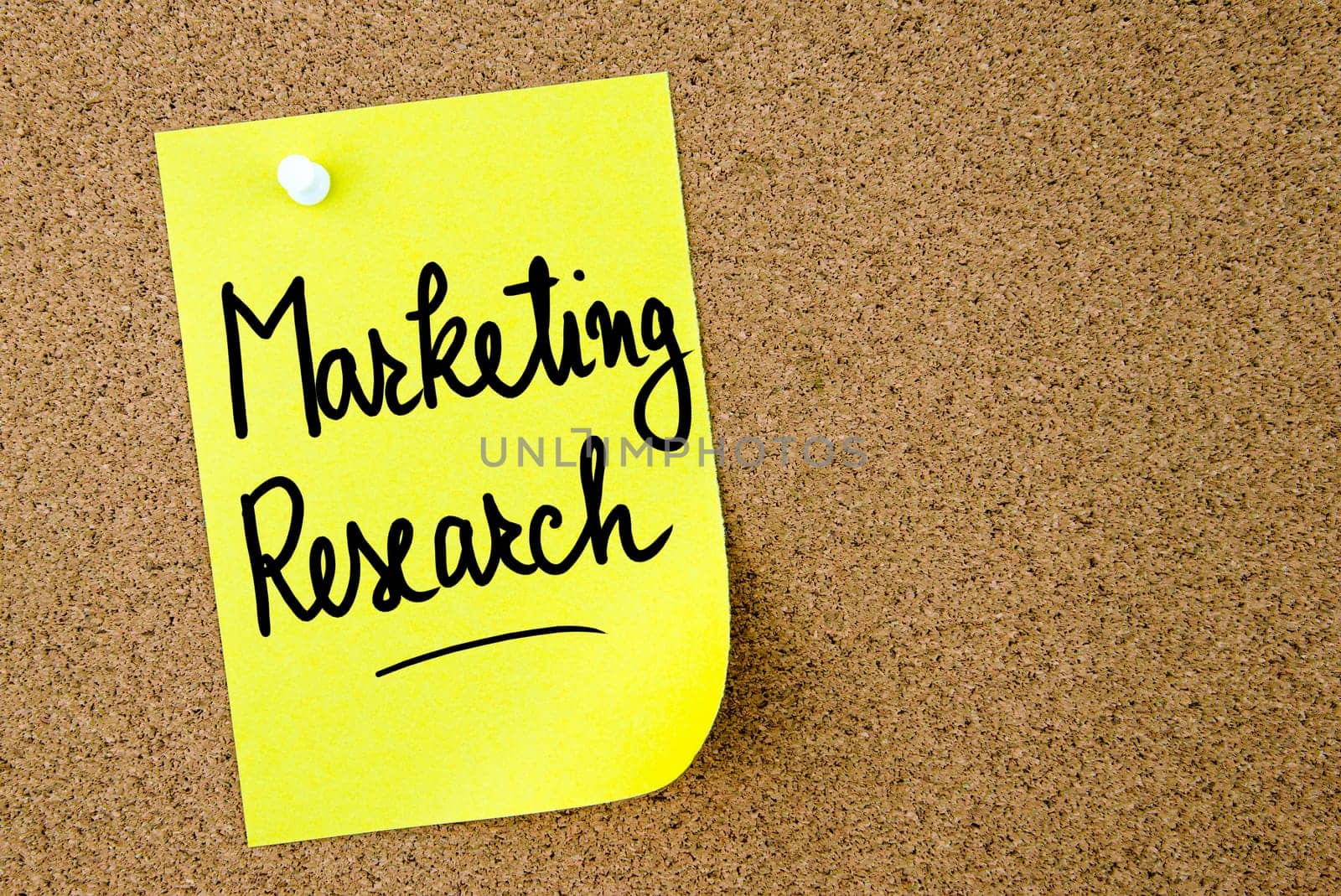 Marketing Research text written on yellow paper note pinned on cork board with white thumbtack. Business concept image with copy space available