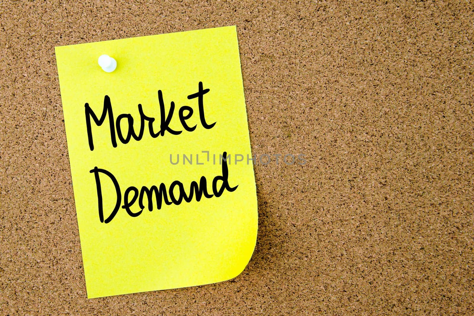 Market Demand text written on yellow paper note pinned on cork board with white thumbtack. Business concept image with copy space available
