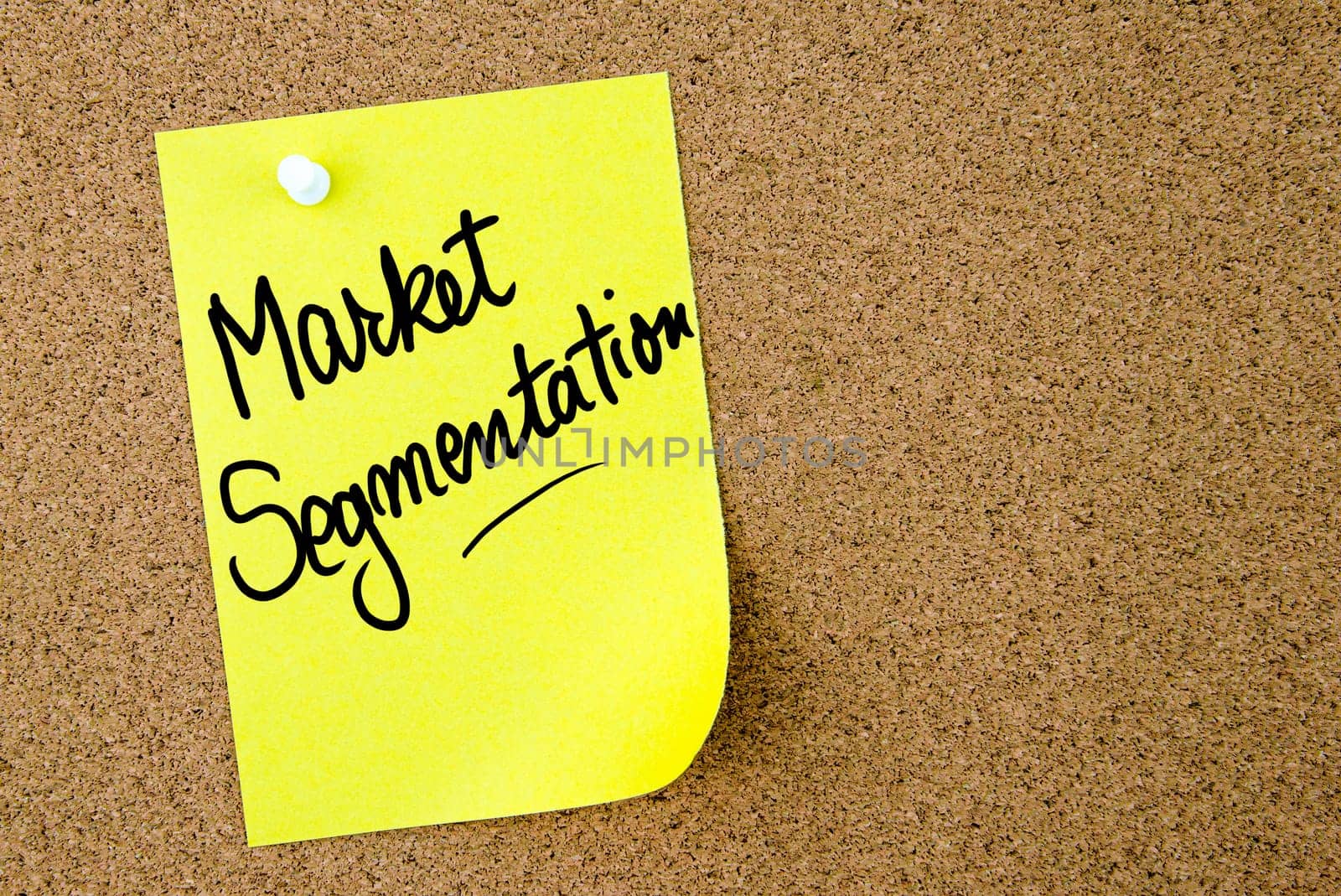 Market Segmentation text written on yellow paper note pinned on cork board with white thumbtack. Business concept image with copy space available