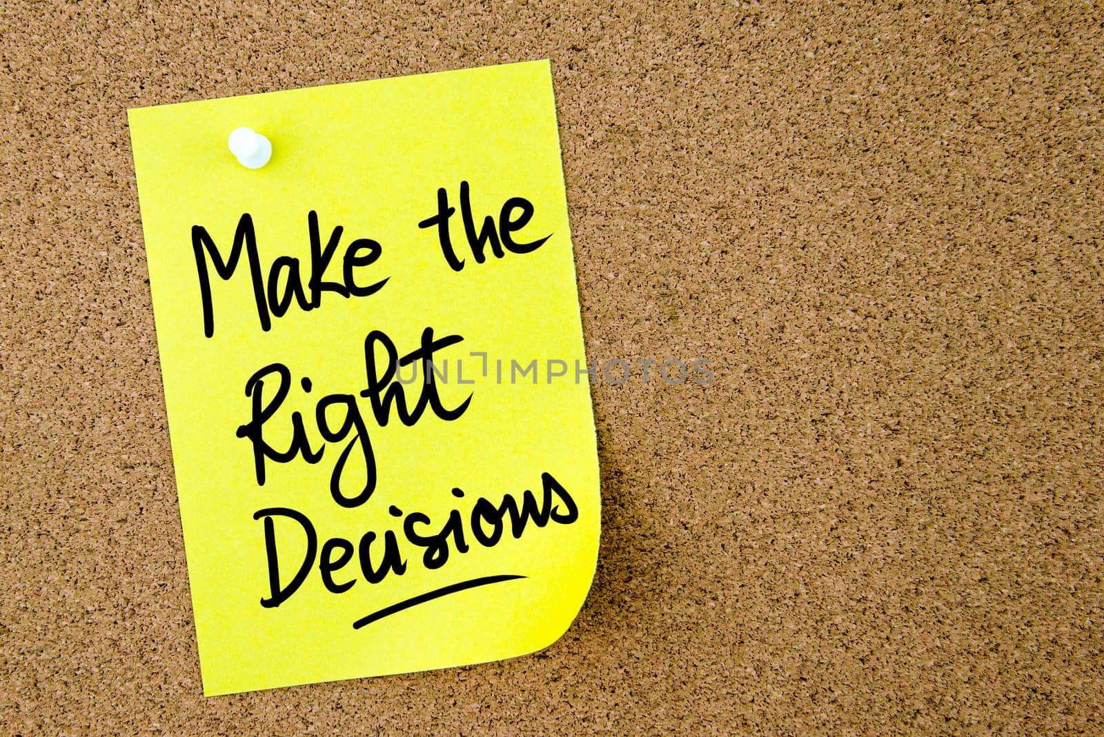Make The Right Decisions text written on yellow paper note pinned on cork board with white thumbtack. Business concept image with copy space available