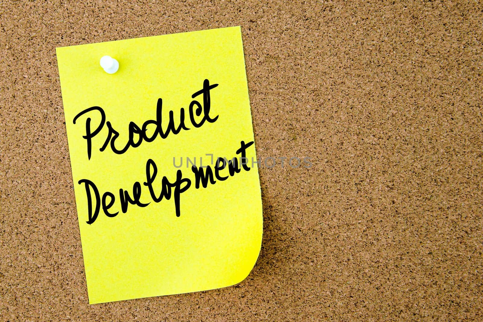 Product Development text written on yellow paper note pinned on cork board with white thumbtack. Business concept image with copy space available