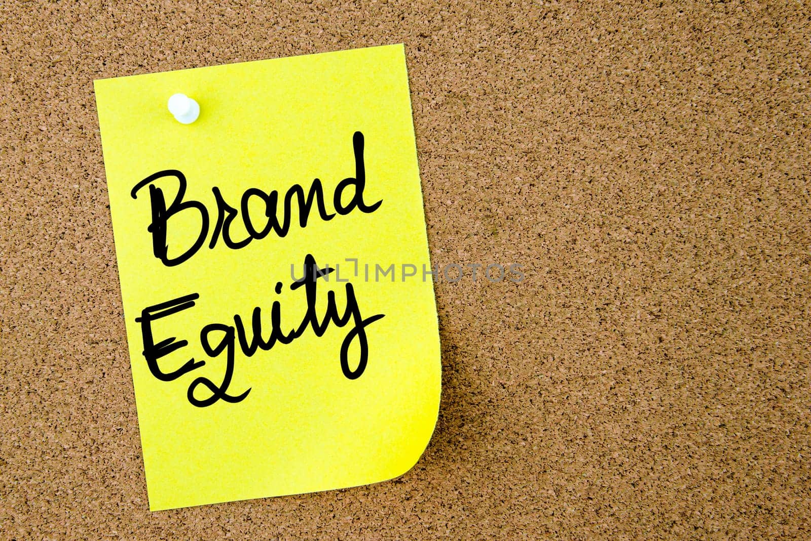Brand Equity text written on yellow paper note pinned on cork board with white thumbtack. Business concept image with copy space available