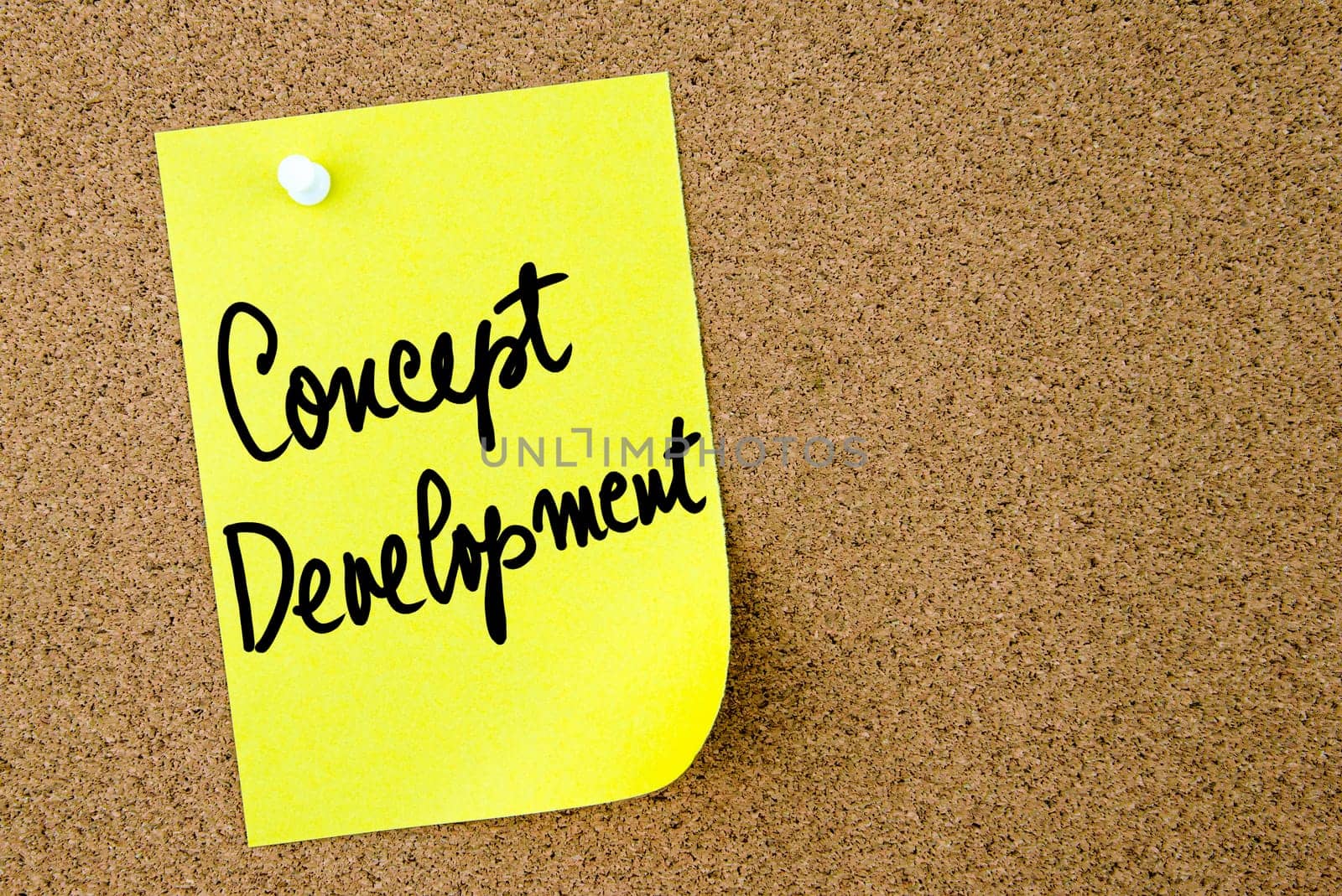 Concept Development text written on yellow paper note pinned on cork board with white thumbtack. Business concept image with copy space available
