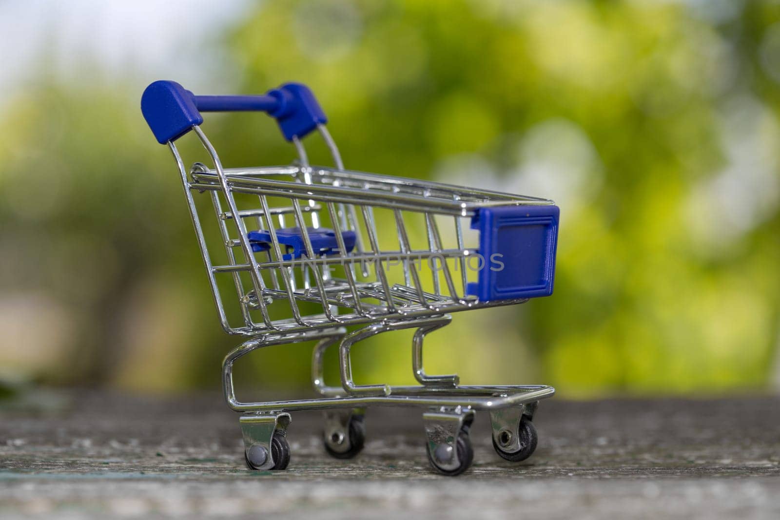small shopping cart, studio picture on a wooden table