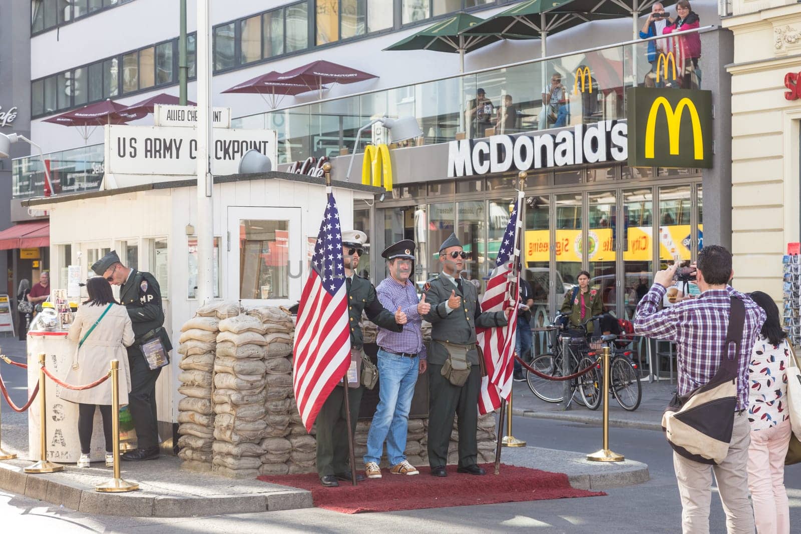 Berlin, Grmany - Sept 19, 2016: Tourist taking pictures and selfies at Checkpoint Charlie, famous Berlin Wall crossing point during the Cold War, on 19th of September, 2016 in Berlin, Germany.