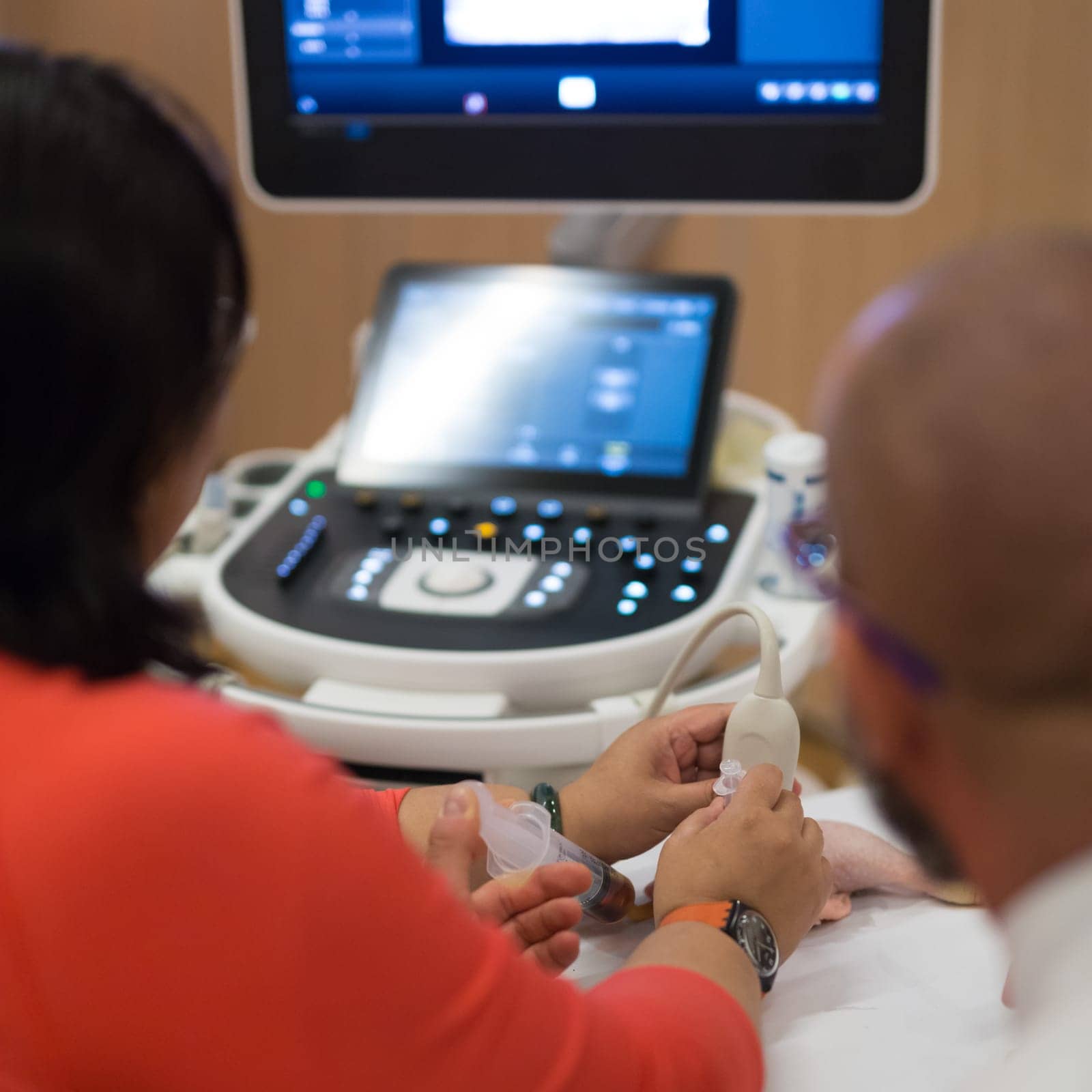 Female medical doctor students learning to do medical examination of patient with ultra sound scanner machine on ultrasound techniques workshop.