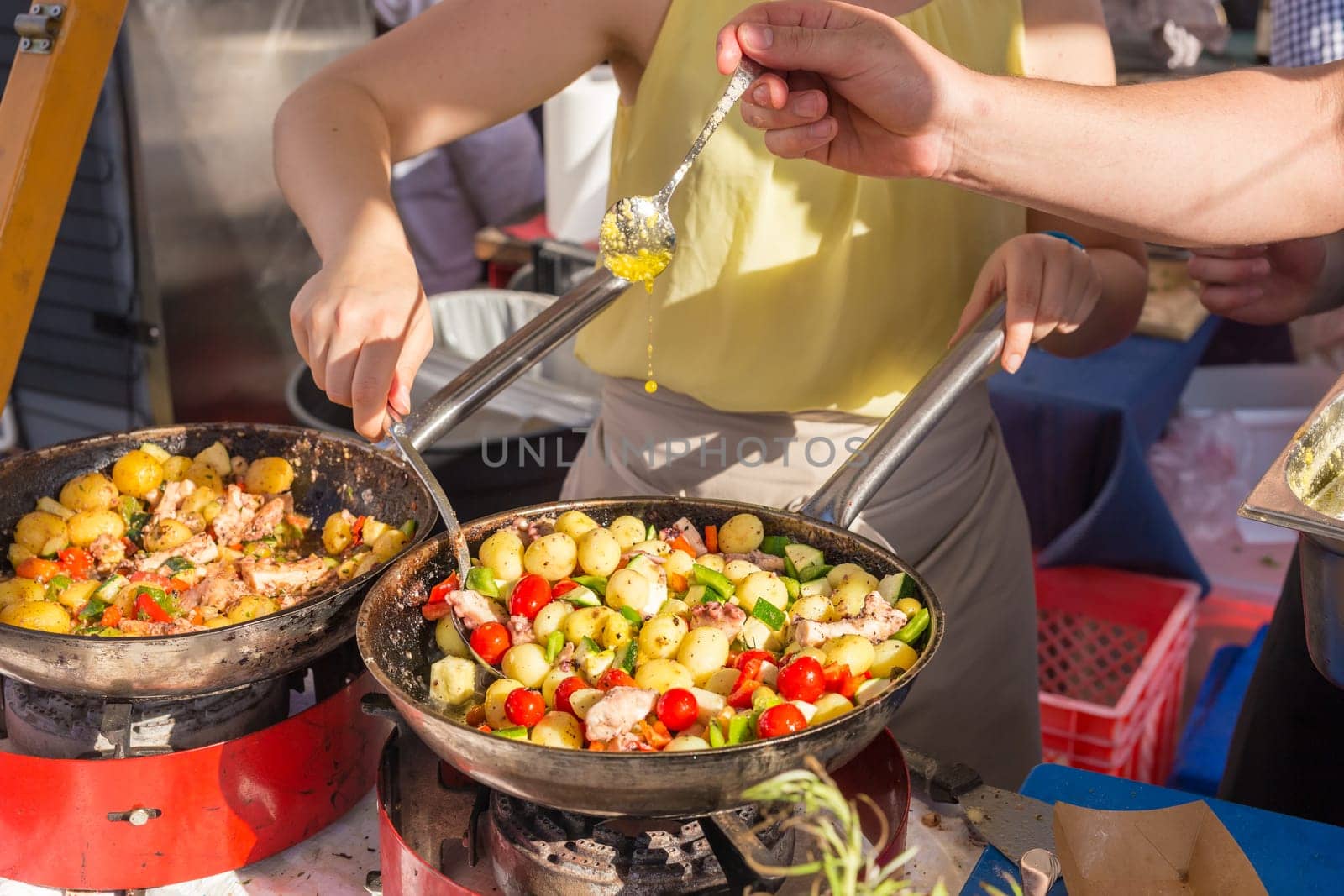 Cheff cooking traditional Mediterranean octopus with potatoes and vegetable on street stall on international street food festival of Odprta kuhna, Open kitchen event, in Ljubljana, Slovenia.