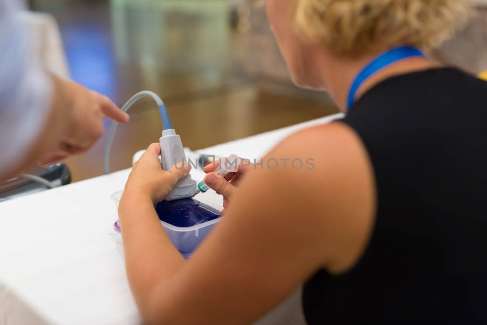 Female medical doctor students learning to do medical examination of patient with ultra sound scanner machine on ultrasound techniques workshop.