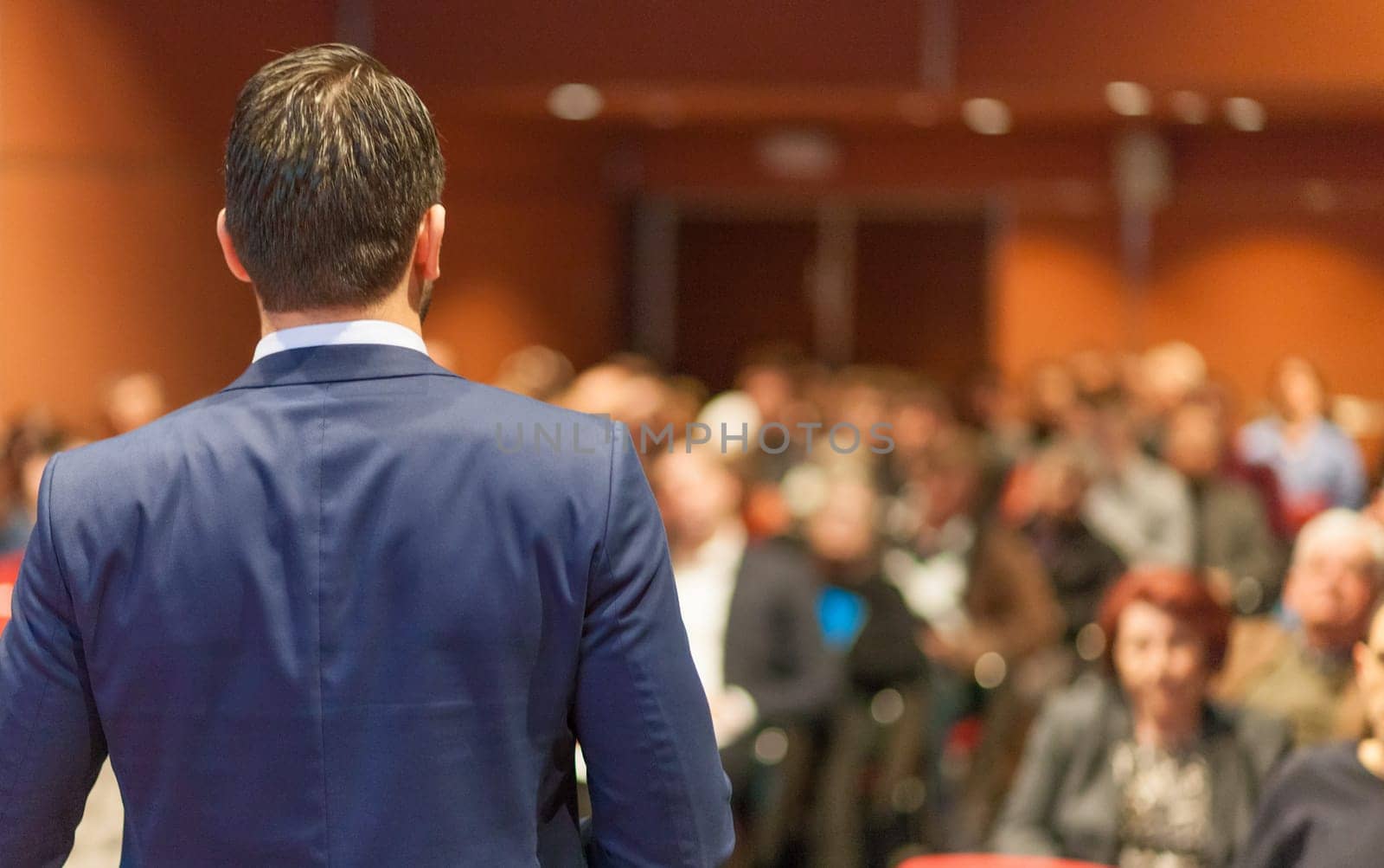 Speaker giving a talk on corporate Business Conference. Audience at the conference hall. Business and Entrepreneurship event.