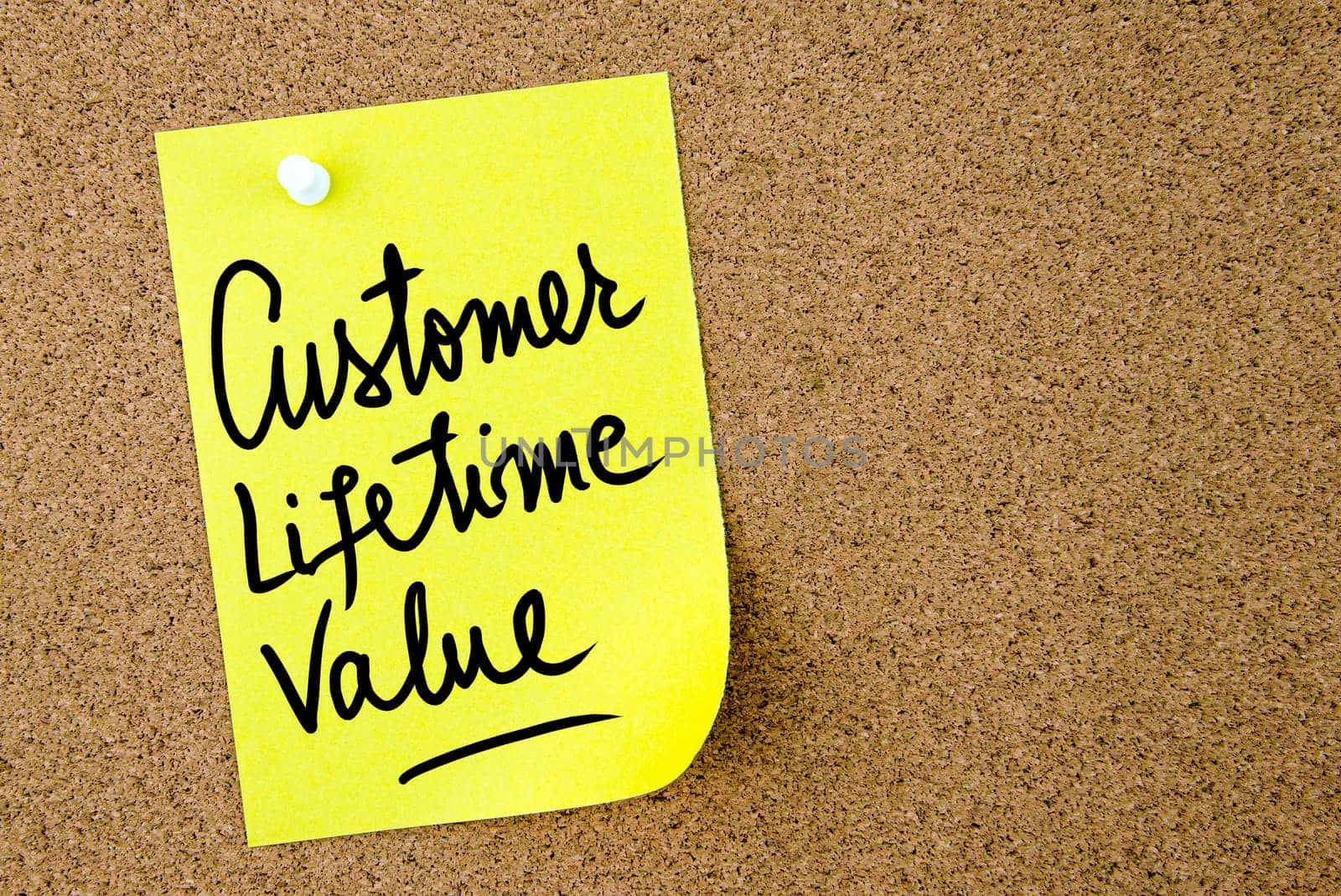 Customer Lifetime Value text written on yellow paper note pinned on cork board with white thumbtack. Business concept image with copy space available
