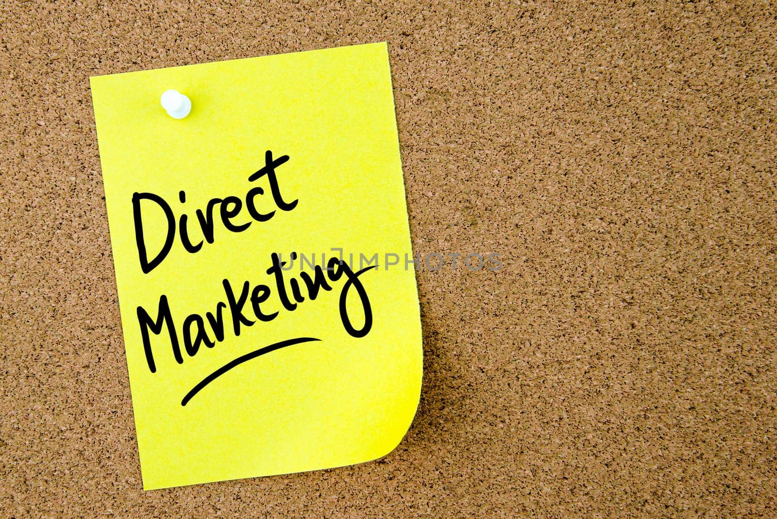 Direct Marketing text written on yellow paper note pinned on cork board with white thumbtack. Business concept image with copy space available