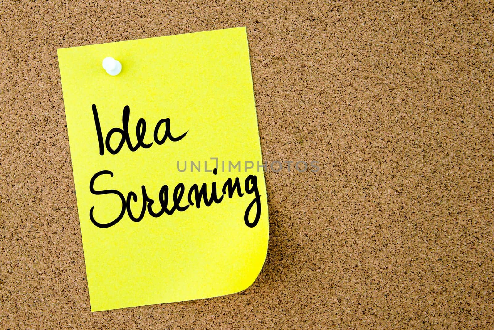 Idea Screening text written on yellow paper note pinned on cork board with white thumbtack. Business concept image with copy space available