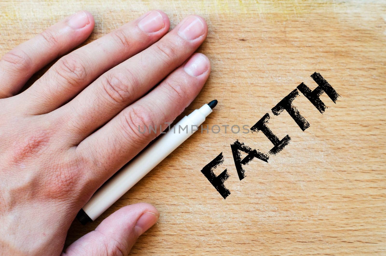Human hand over wooden background and faith text concept