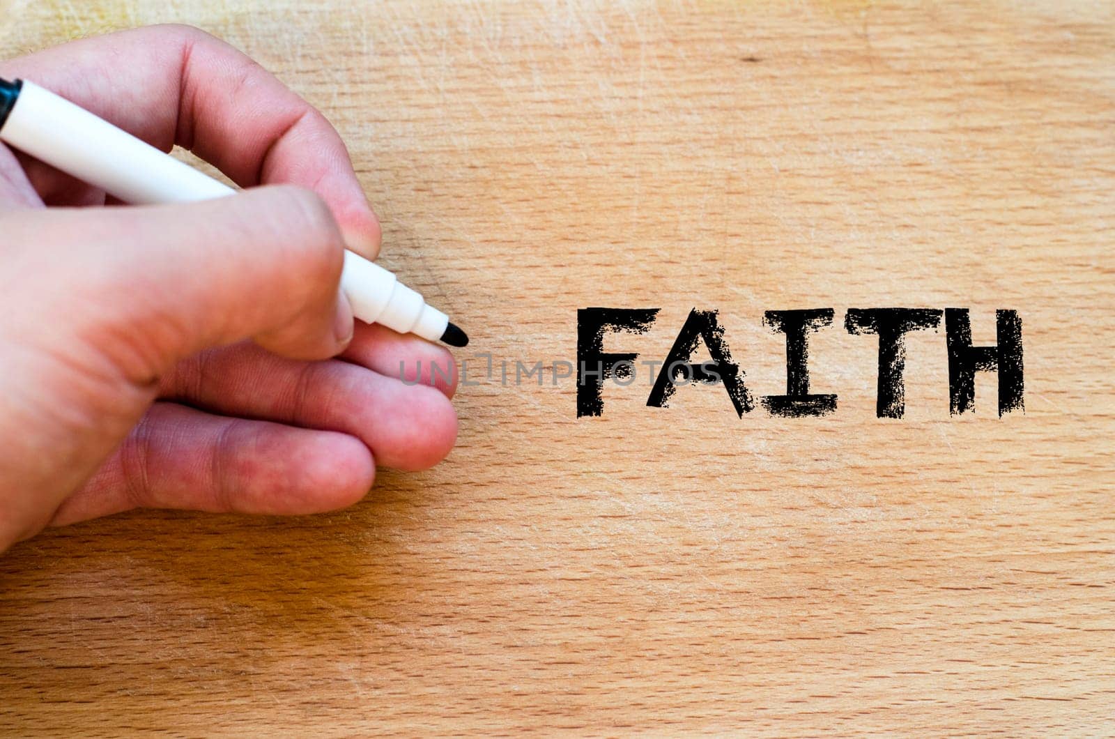 Human hand over wooden background and faith text concept