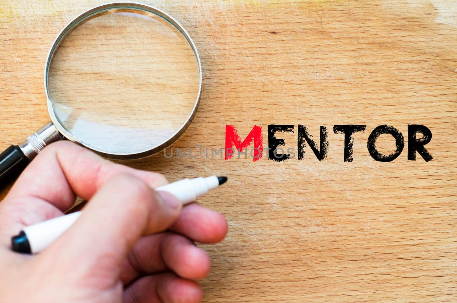Human hand over wooden background and mentor text concept