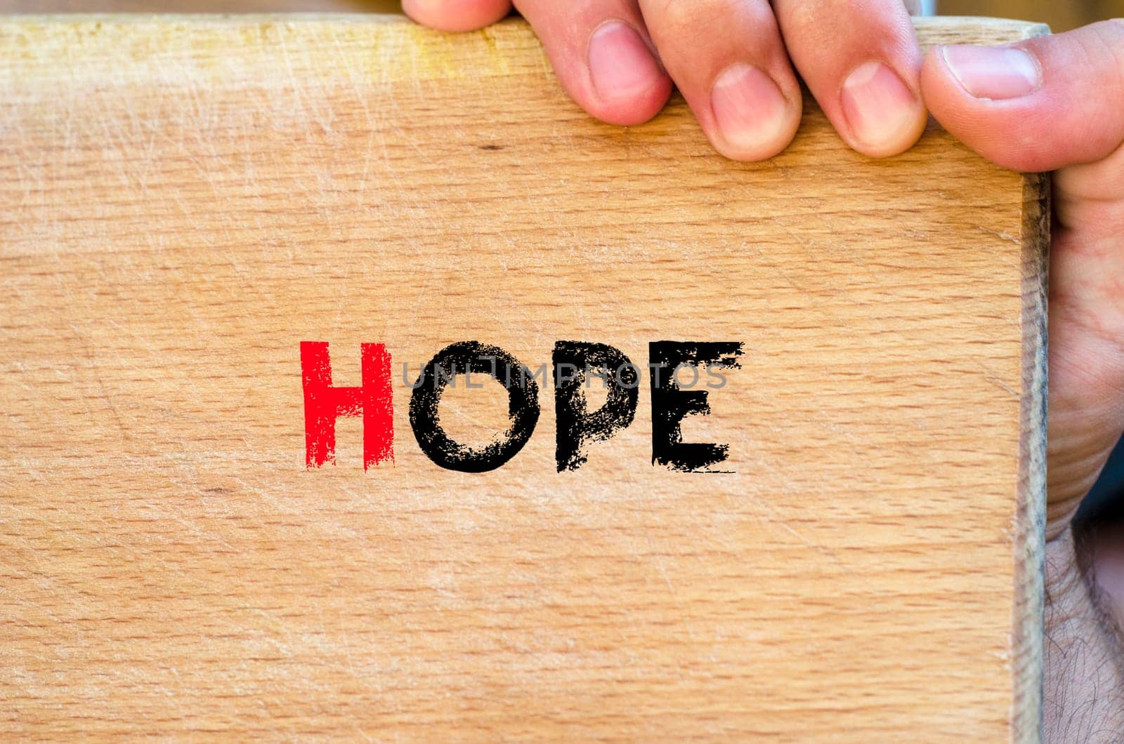 Human hand over wooden background and hope text concept